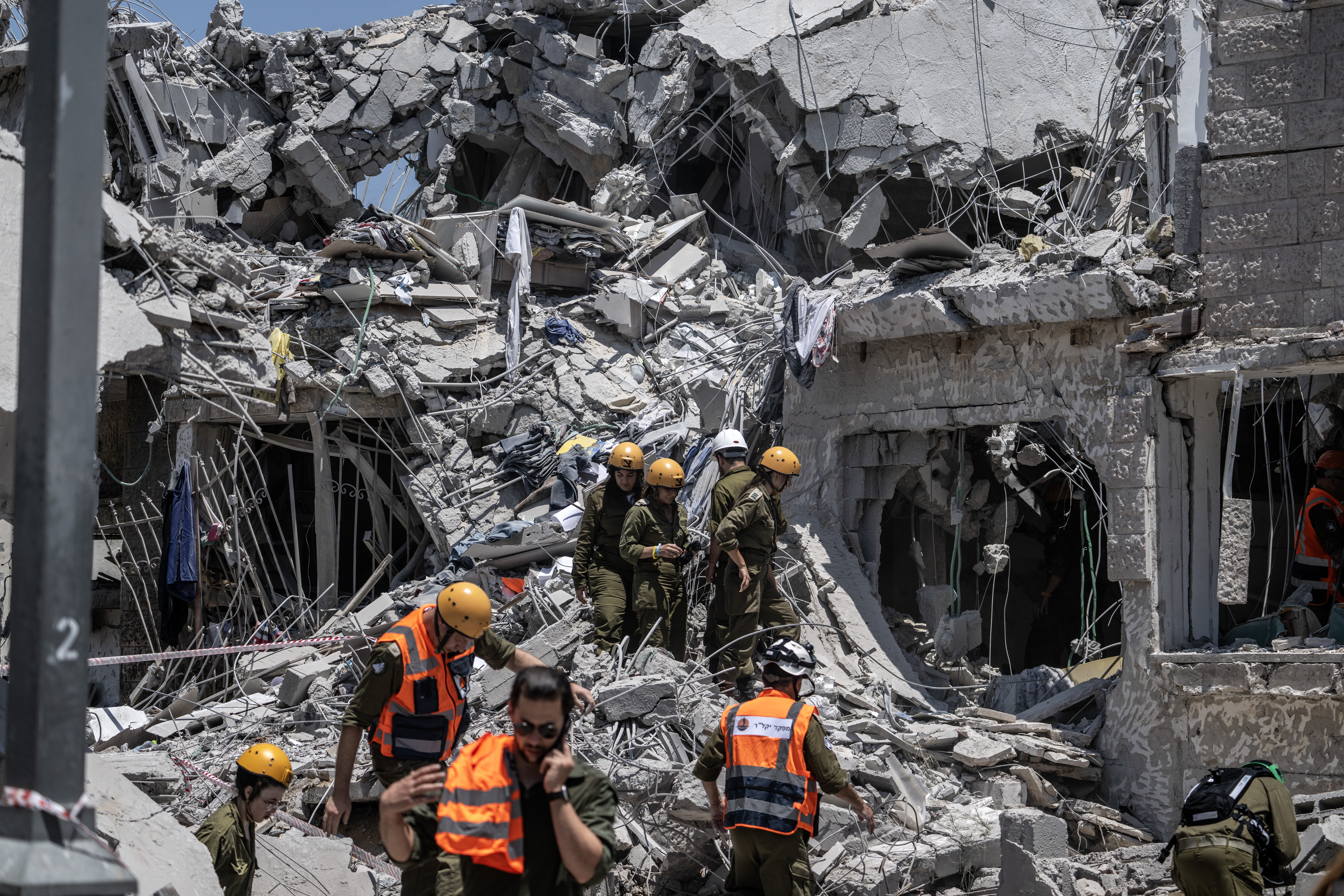 Israeli search and rescue team conduct operation amid the rubble of destroyed building after the attacks of Iranian army following the launch of large-scale Israeli strikes against Iran in Rishon LeZion, Israel on June 14, 2025. [Mostafa Alkharouf/Anadolu Agency]