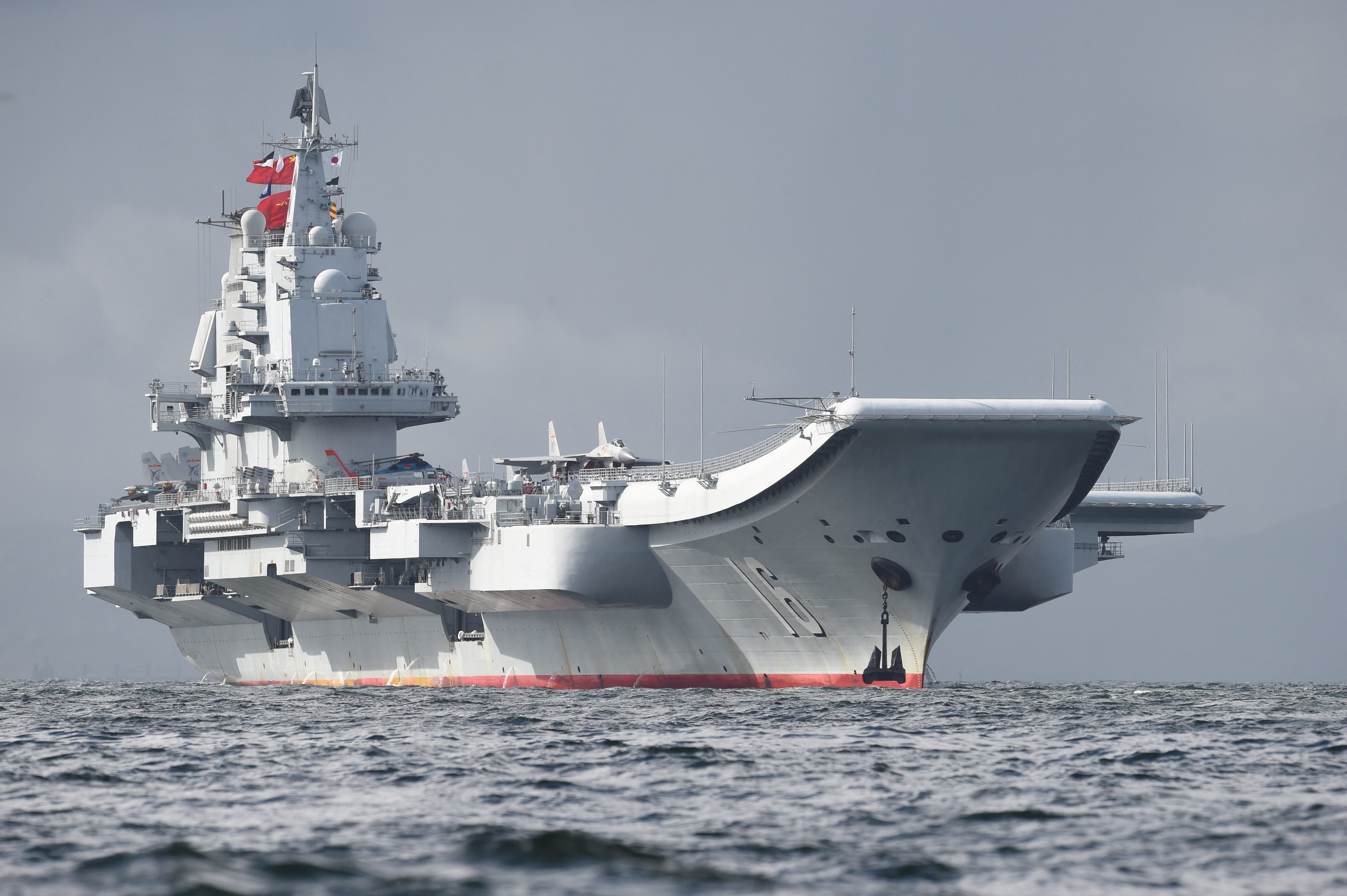 China's sole aircraft carrier, the Liaoning, arrives in Hong Kong waters on July 7, 2017, less than a week after a high-profile visit by president Xi Jinping. China's national defence ministry had said the Liaoning, named after a northeastern Chinese province, was part of a flotilla on a "routine training mission" and would make a port of call in the former British colony. (Photo by Anthony WALLACE / AFP)