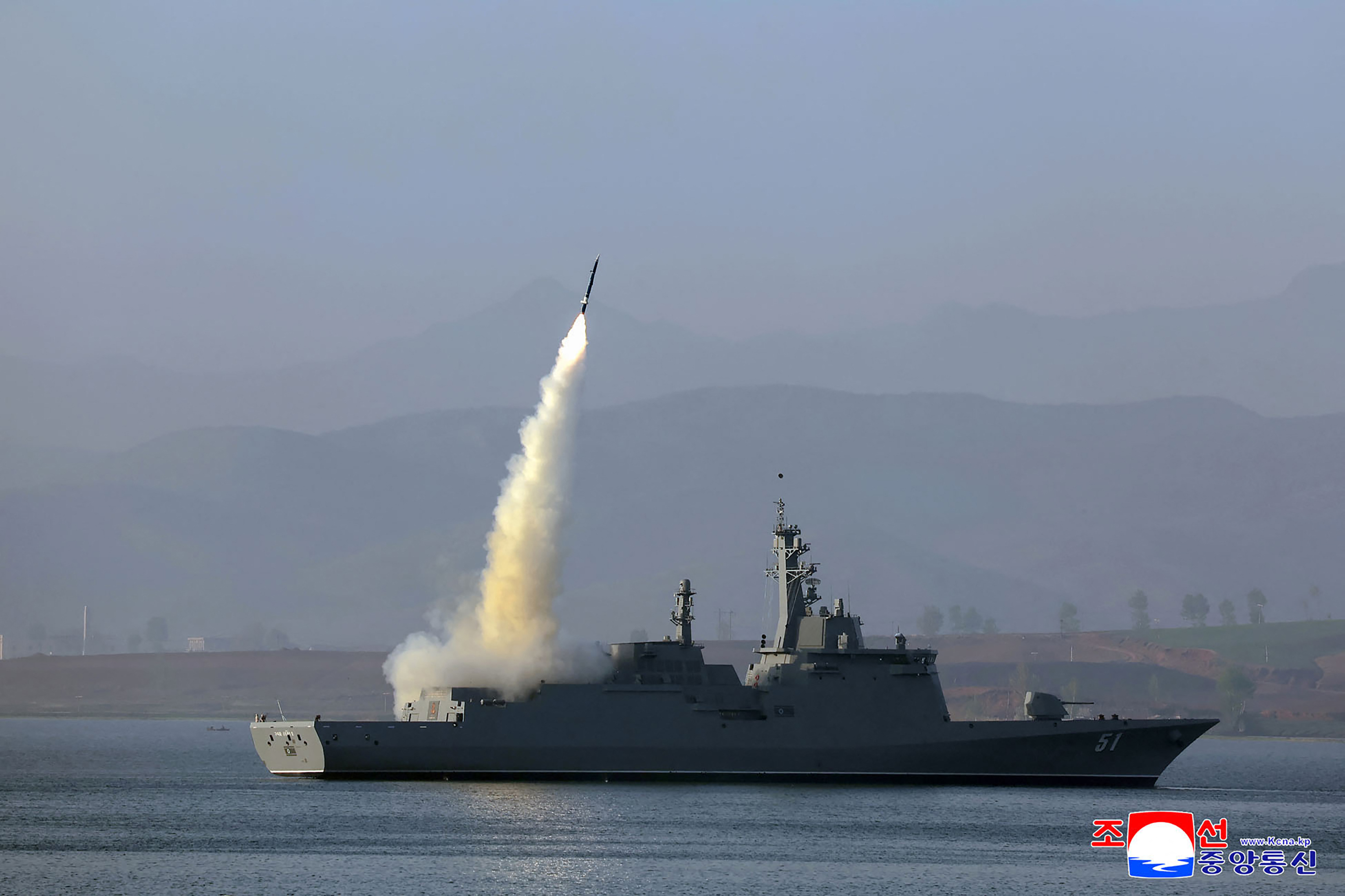 A rocket shoots off into the air from a destroyer ship.