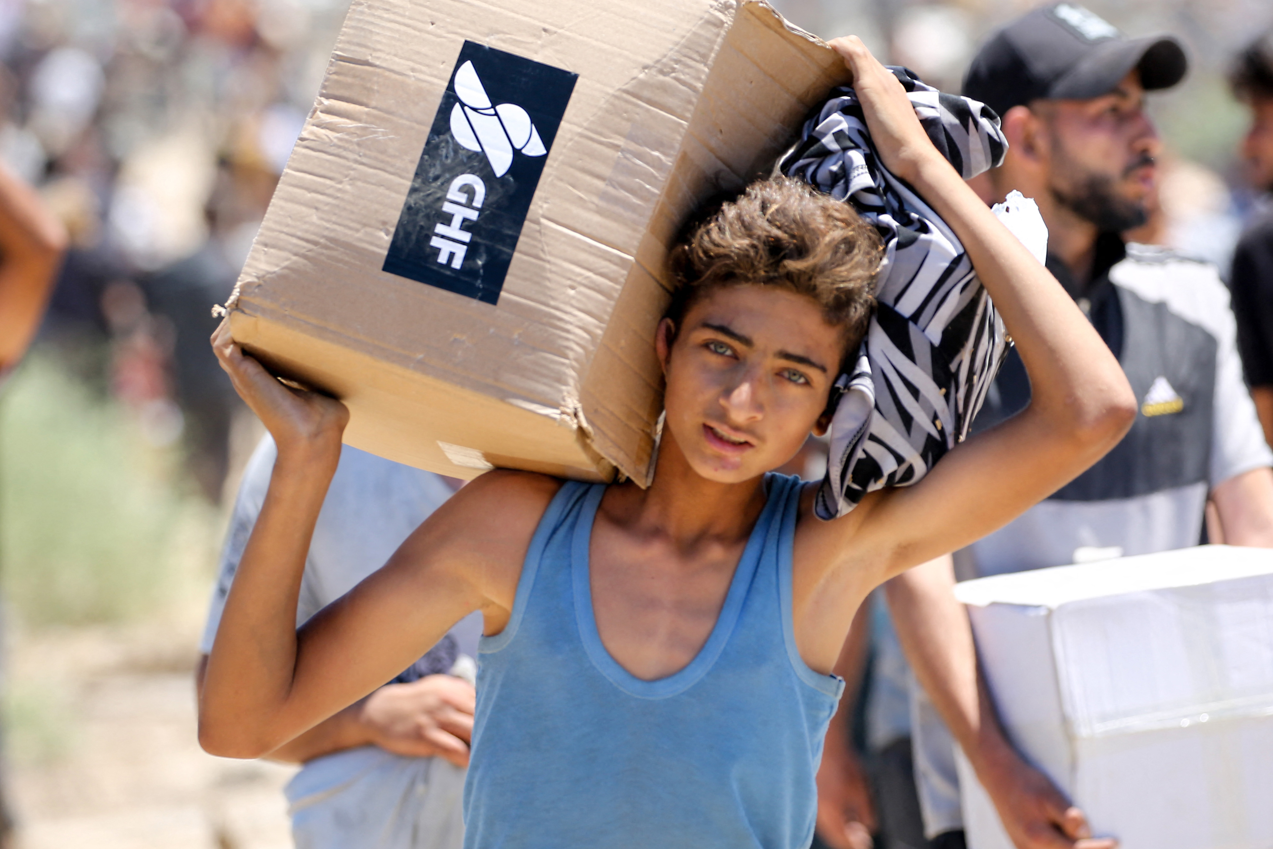 A Palestinian child carries aid distributed by the Gaza Humanitarian Foundation