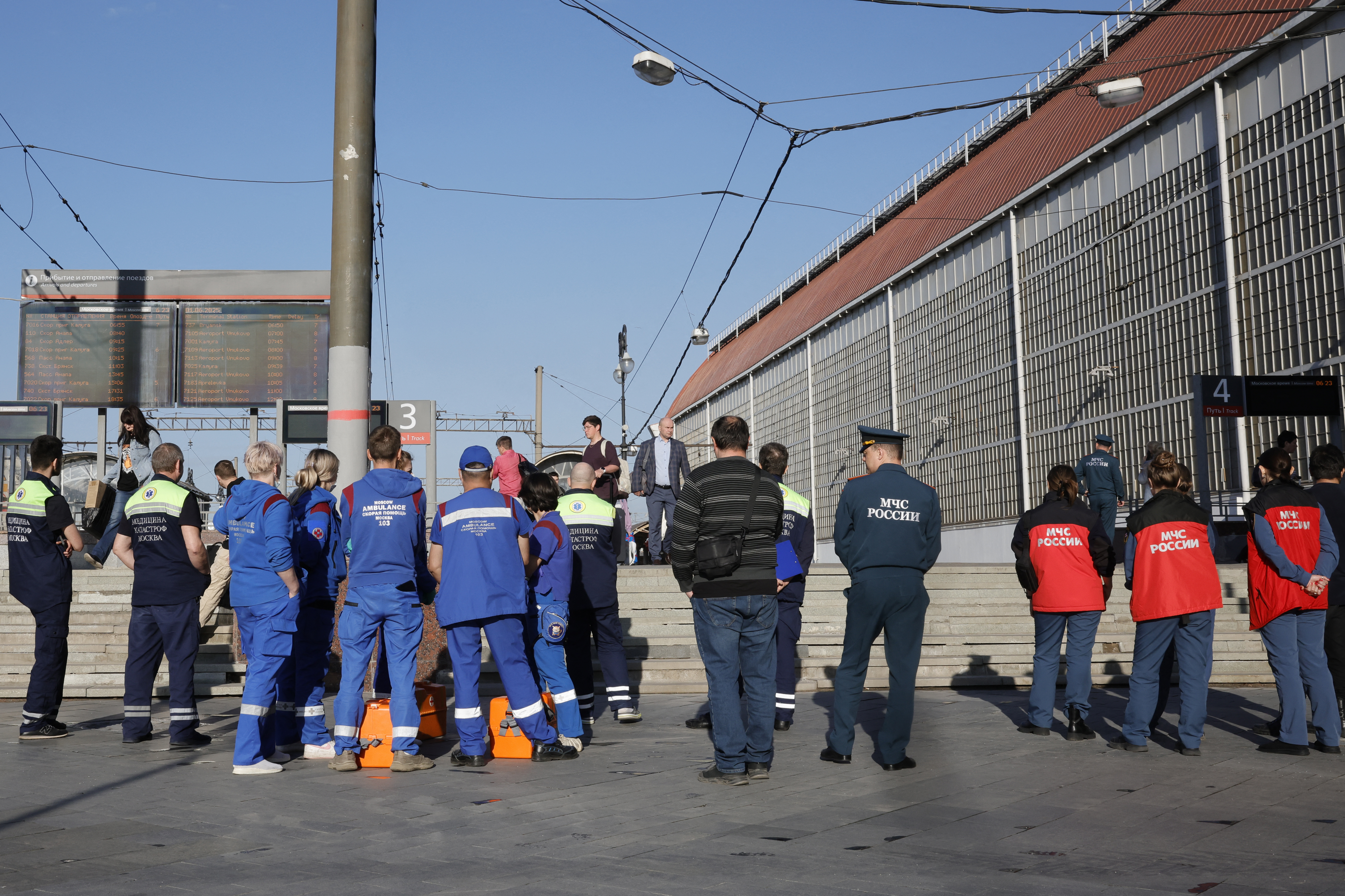 people in uniforms stand with their backs to the camera 
