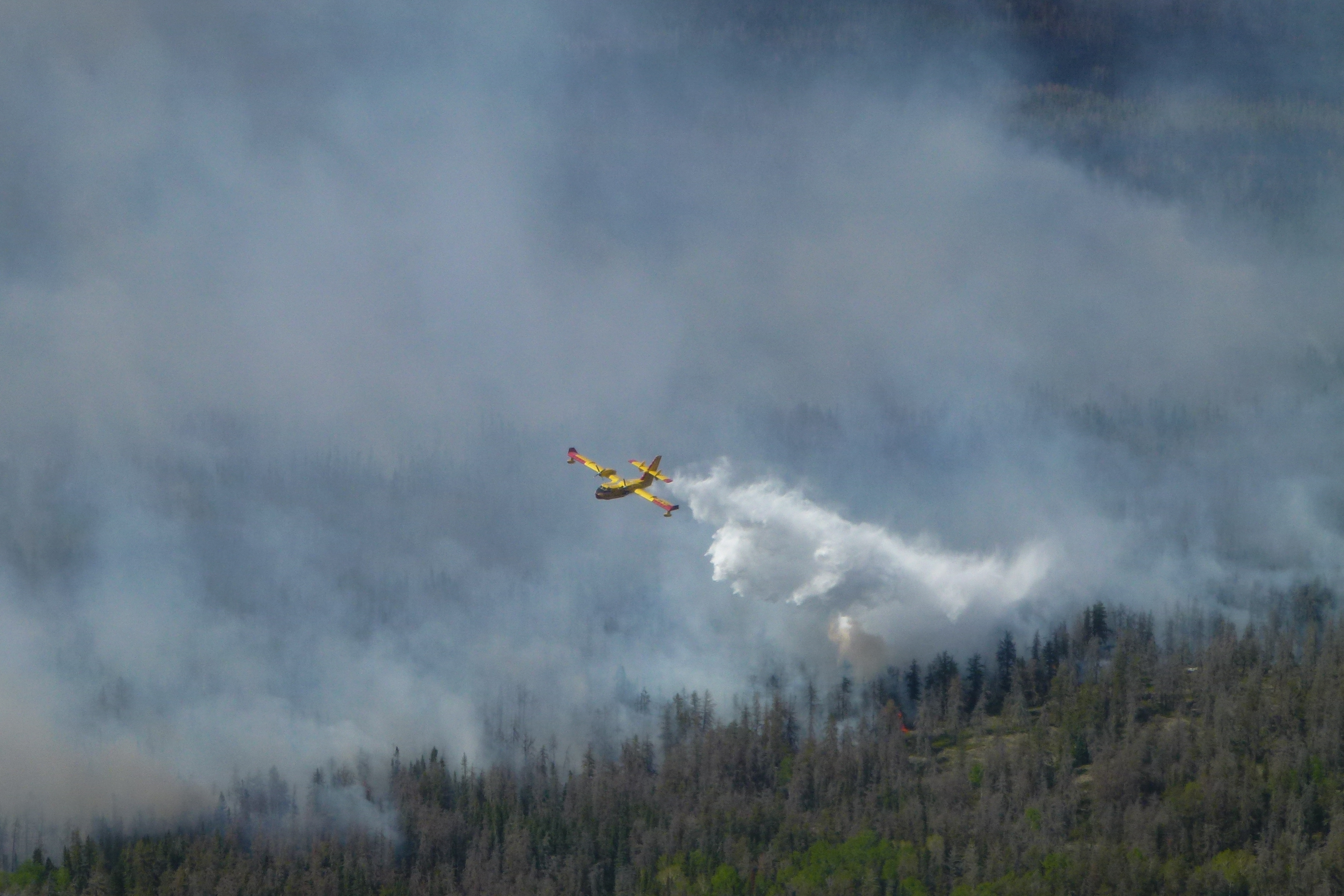 This May 29, 2025, aerial image courtesy of the Manitoba Government, shows a firefighting plane as wildfires burn in the Nopiming Provincial Park in the area of Bird River, Manitoba, Canada. More than 17,000 people in Canada's western Manitoba province were being evacuated on May 28, 2025, as the region experienced its worst start to a wildfire season in years. "The Manitoba government has declared a province-wide state of emergency due to the wildfire situation," Manitoba Premier Wab Kinew told a news conference. (Photo by HANDOUT / Manitoba Government / AFP) / RESTRICTED TO EDITORIAL USE - MANDATORY CREDIT "AFP PHOTO / SOURCE / COURTESY OF THE MANITOBA GOVERNMENT" - HANDOUT - NO MARKETING NO ADVERTISING CAMPAIGNS - DISTRIBUTED AS A SERVICE TO CLIENTS