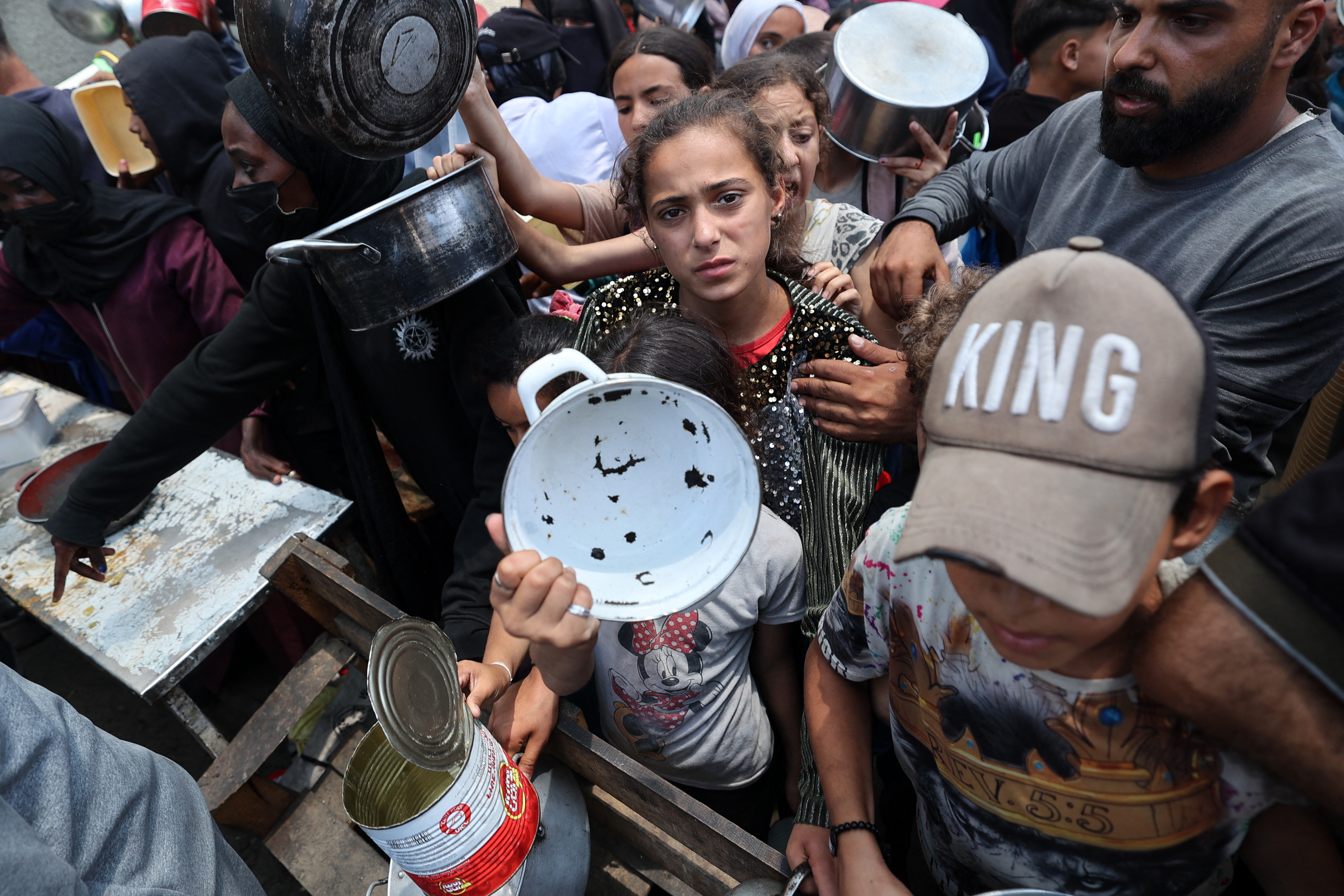 Palestinian children gather at a hot meal distribution point in Nuseirat in the central Gaza Strip, June 4, 2025. The US and Israeli-backed Gaza Humanitarian Foundation (GHF) group operating aid sites in the Gaza Strip announced the temporary closure of the facilities on June 4, following a string of deadly incidents near the distribution sites it operates that have sparked condemnation from the United Nations. (Photo by Eyad BABA / AFP)
