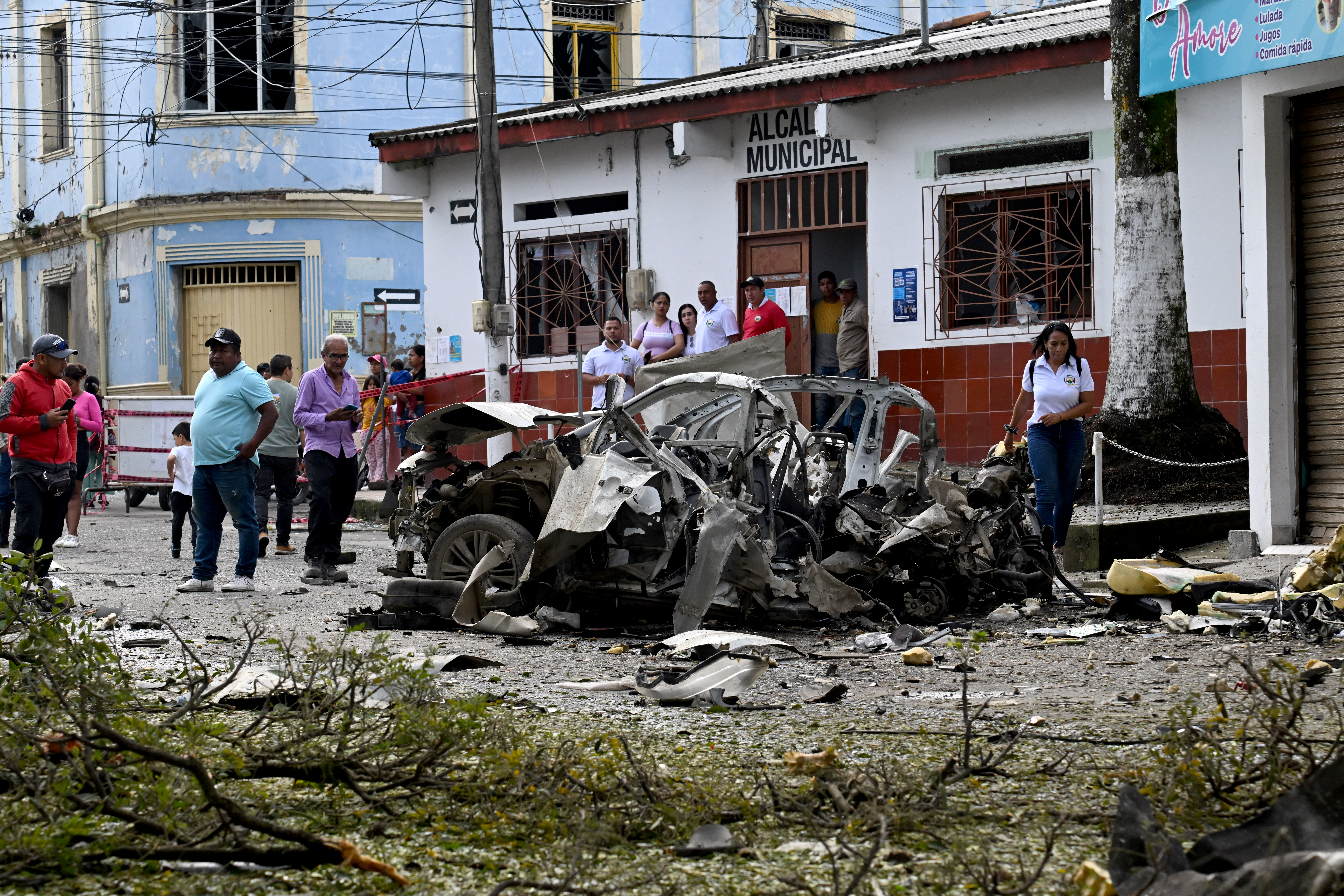 Bystanders look at the wreckage of a car after it exploded in front of the City Hall in Corinto, Cauca department, Colombia on June 10, 2025.