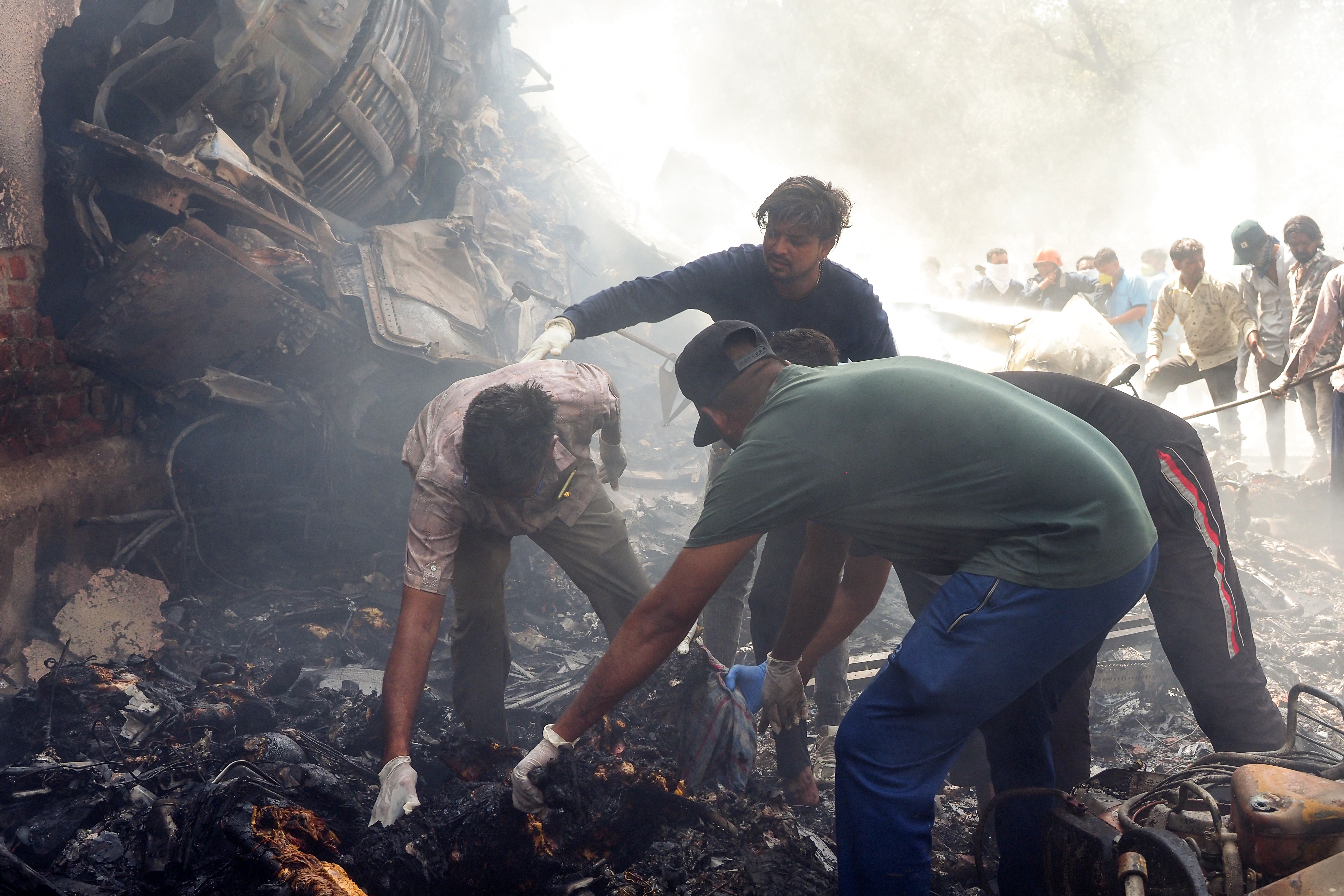 Firefighters work to put out a fire at the site where an Air India plane