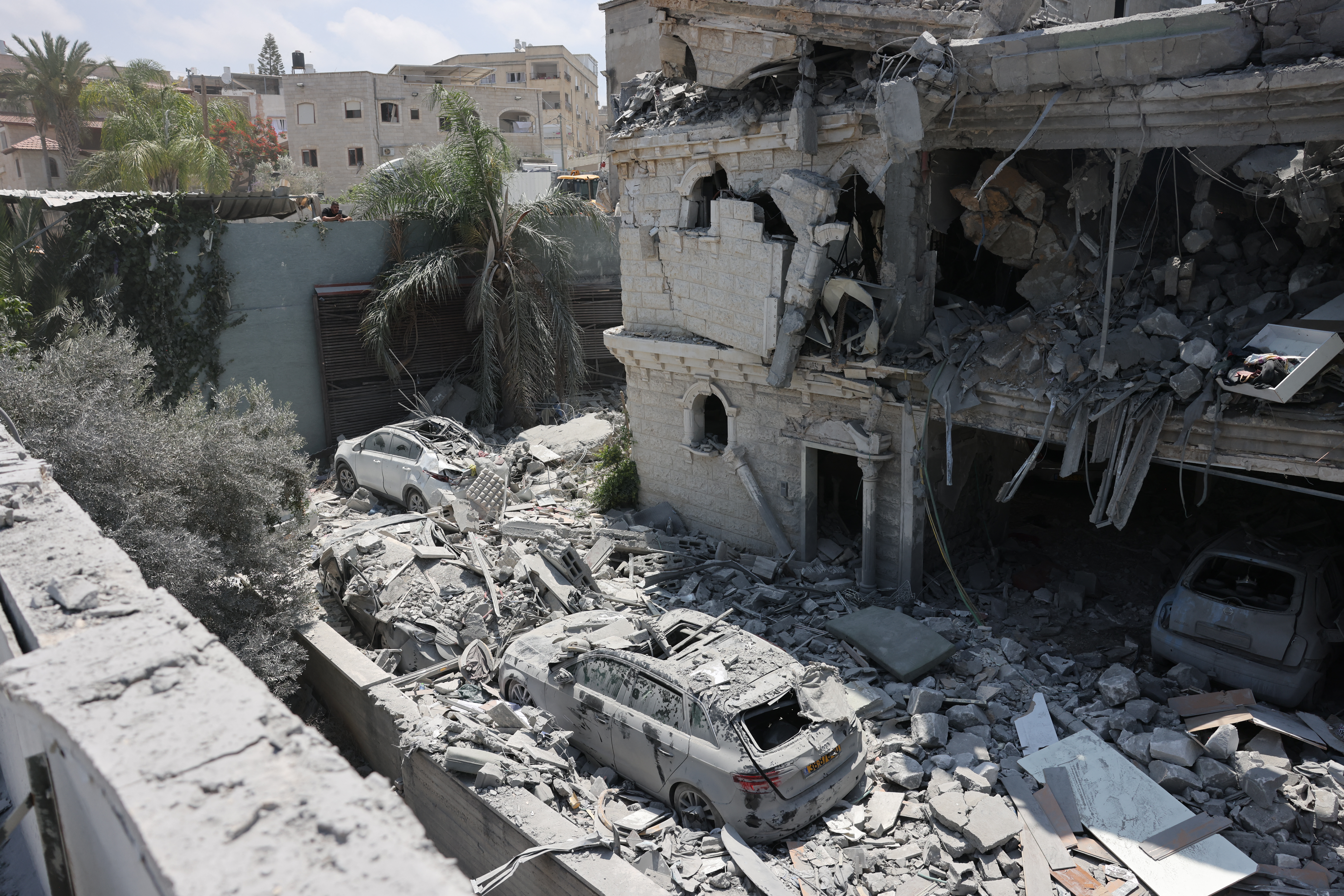 Damaged cars lie amid the rubble of a damaged building in the northern Israeli town of Tamra, following an overnigh missile attack from Iran on June 15, 2025, where four people, including a child, were reported killed. Iranian missile fire on Israel killed at least 10 people overnight, authorities said on June 15, as the foes exchanged new waves of attacks in their most intense confrontation in history. (Photo by AHMAD GHARABLI / AFP)