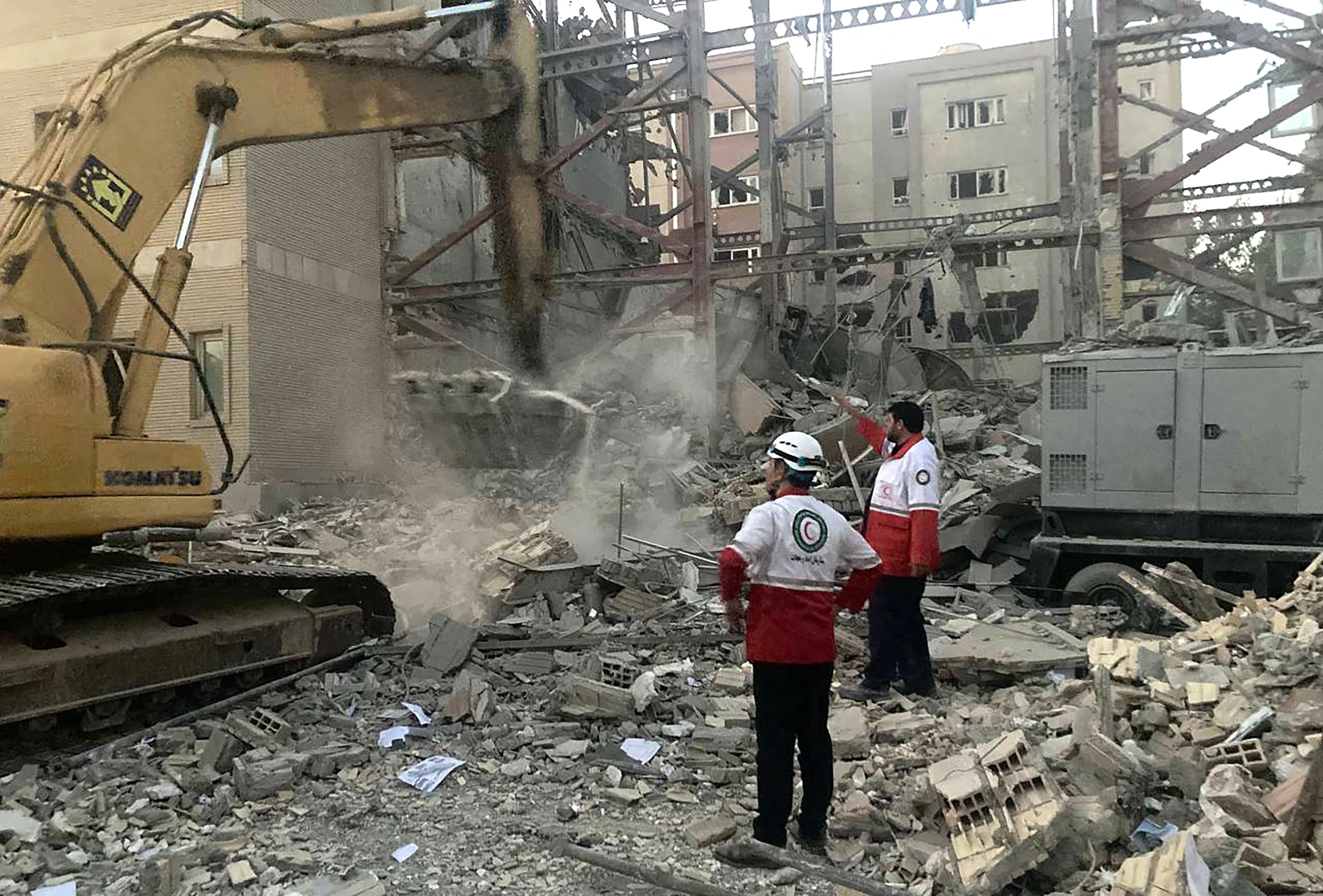 This handout picture provided by the Iranian Red Crescent on June 19, 2025 shows members of their rescue teams clearing debris at a building destroyed during an Israeli attack in Tehran. The Iranian Red Crescent said on June 18 that an Israeli attack took place near its building in Tehran, on the sixth day of an air war between Iran and Israel, noting that the strike appeared to not be targeting the aid group. (Photo by Iranian Red Crescent / AFP) / === RESTRICTED TO EDITORIAL USE - MANDATORY CREDIT "AFP PHOTO / HO / IRANIAN RED CRESCENT" - NO MARKETING NO ADVERTISING CAMPAIGNS - DISTRIBUTED AS A SERVICE TO CLIENTS ===
