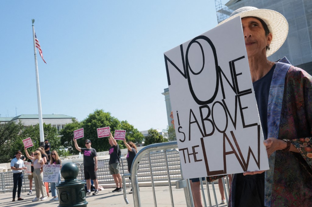 Protestors holding signs stand outside of the US Supreme Court on June 20, 2025 in Washington, DC. [Kayla Bartkowski/Getty Images/AFP]