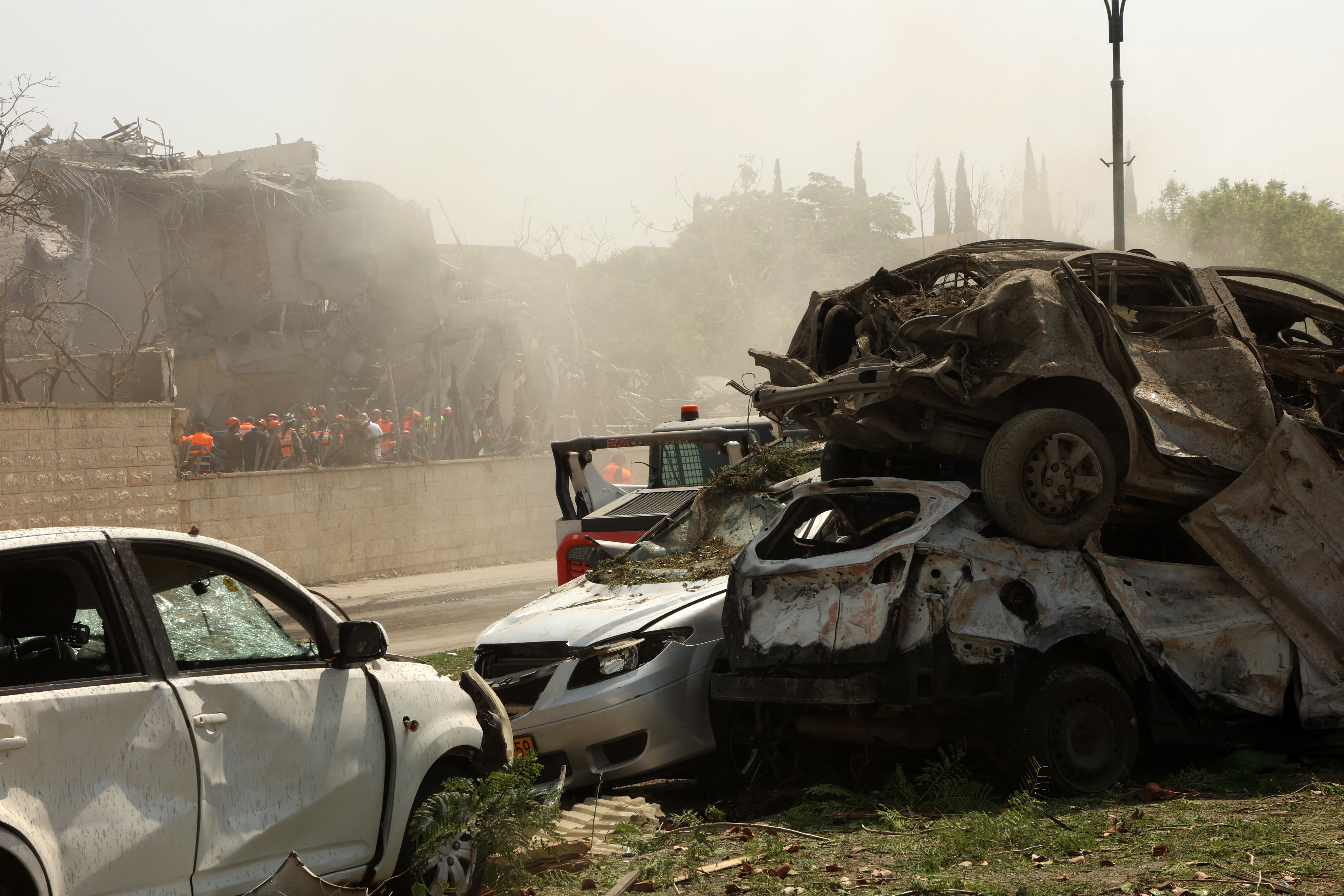 Israeli security forces and rescue teams gather at the scene of an Iranian strike that hit Ness Ziona