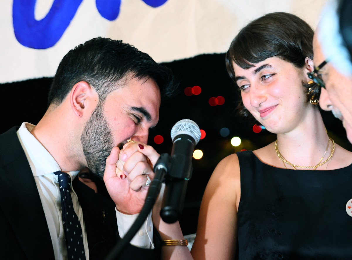 New York mayoral candidate, State Rep. Zohran Mamdani kisses the hand of his wife Rama Duwaji as they celebrate during an election night gathering at The Greats of Craft LIC on June 24, 2025 Michael M. Santiago/Getty Images/AFP