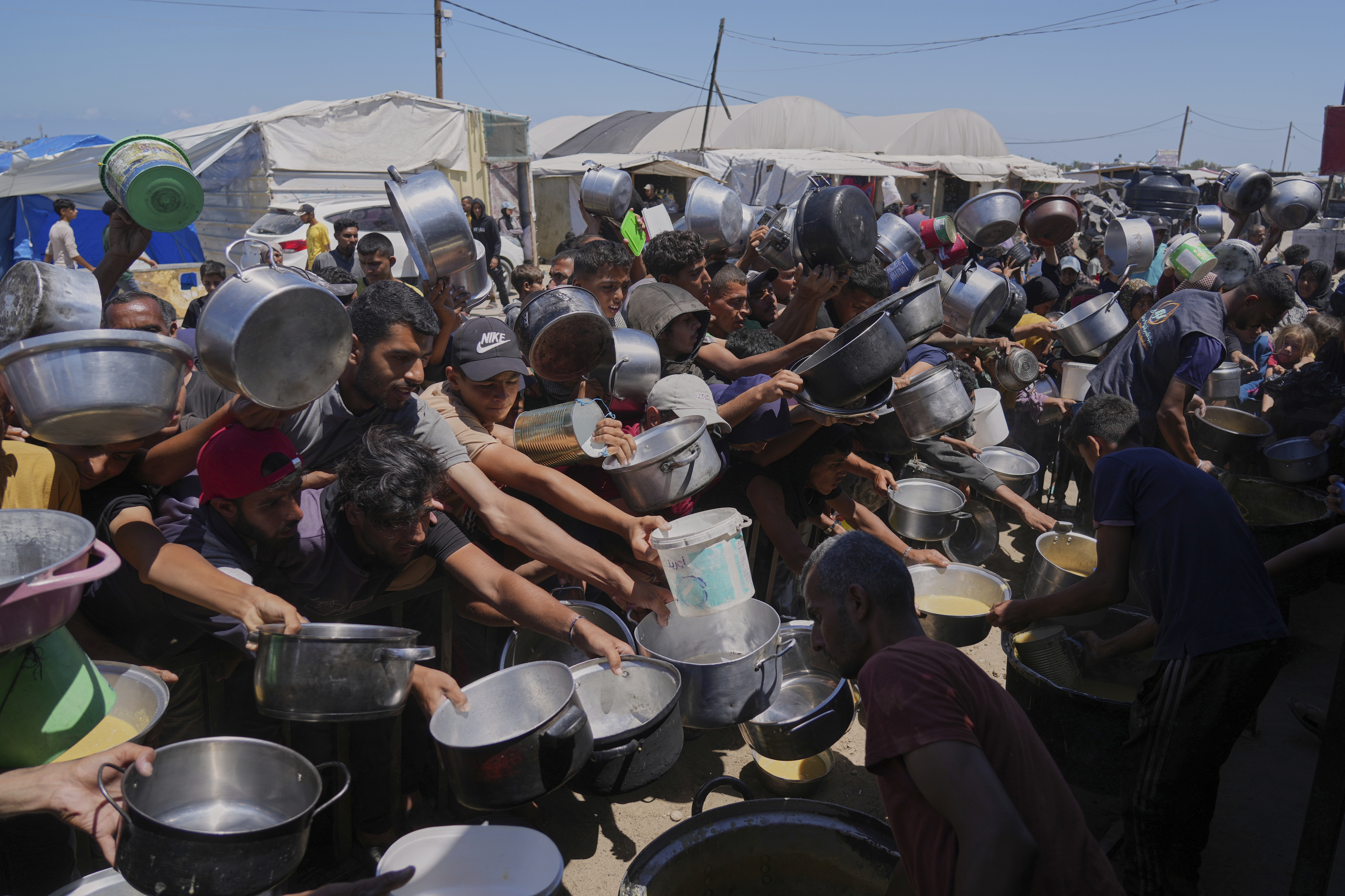 Palestinians struggle to get food at a community kitchen in Khan Younis, southern Gaza Strip