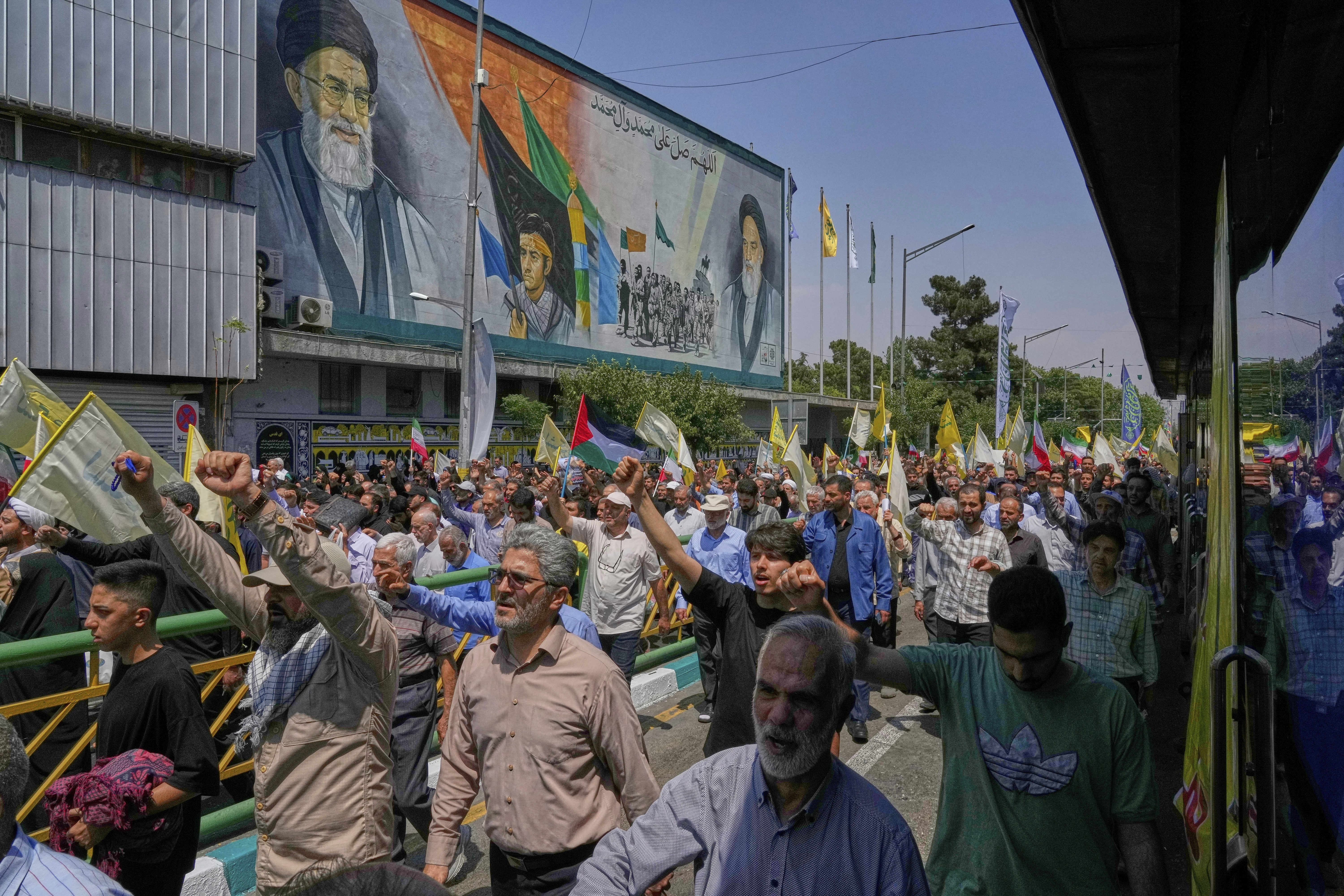 Iranian worshippers attend an anti-Israeli rally under portraits of the Supreme Leader Ayatollah Ali Khamenei, left, and the late revolutionary founder Ayatollah Khomeini, right, after their Friday prayers in Tehran, Iran, Friday, June 13, 2025. (AP Photo/Vahid Salemi)