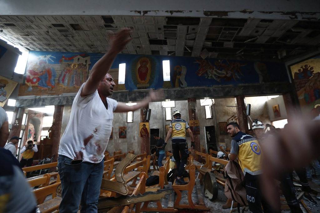 A Syrian man reacts inside Mar Elias church after attack