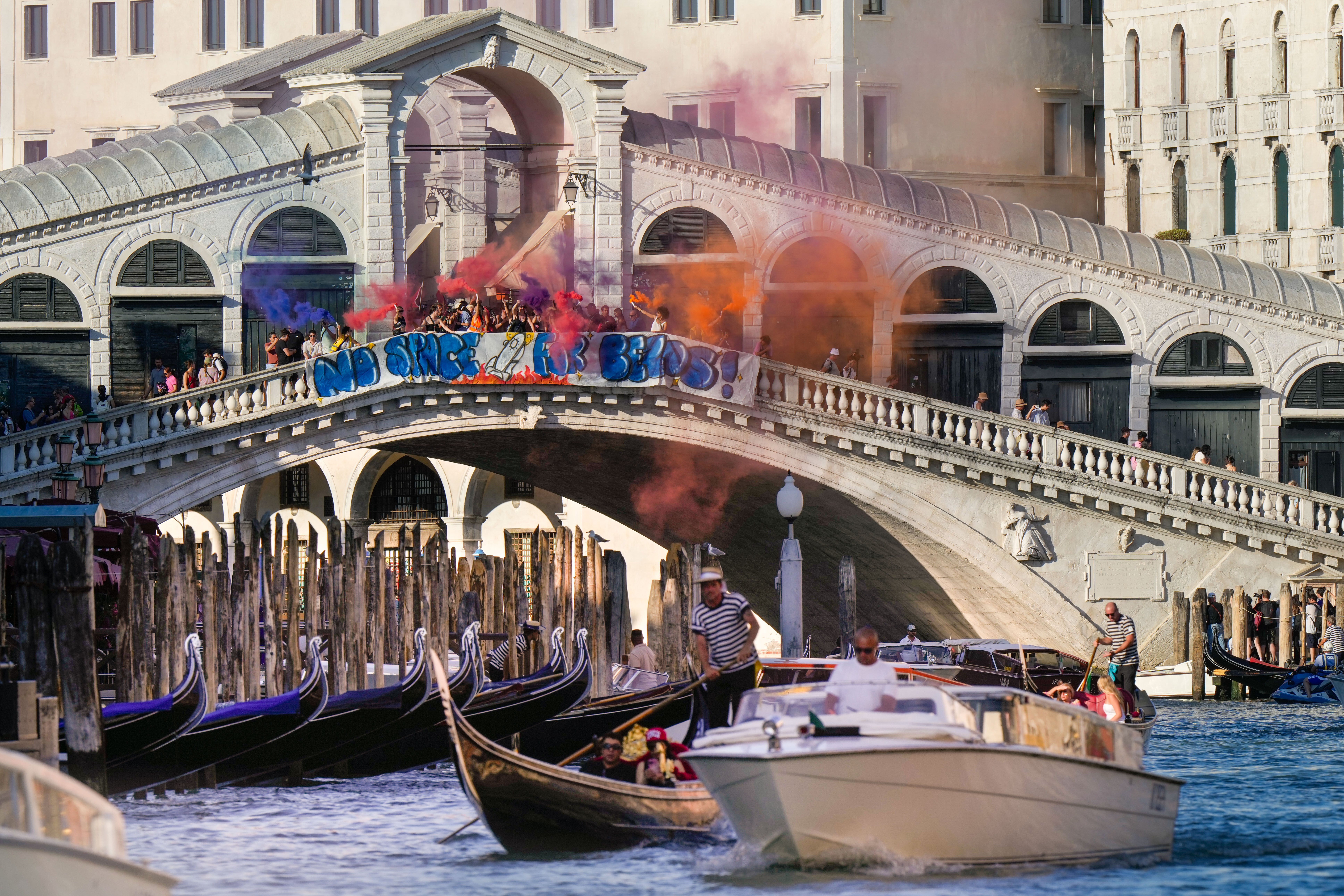 Activists stage a protest on the Rialto Bridge in Venice, Italy, Saturday, June 28, 2025, denouncing the three-day celebrations for the wedding between Jeff Bezos and his wife Lauren Sanchez Bezos