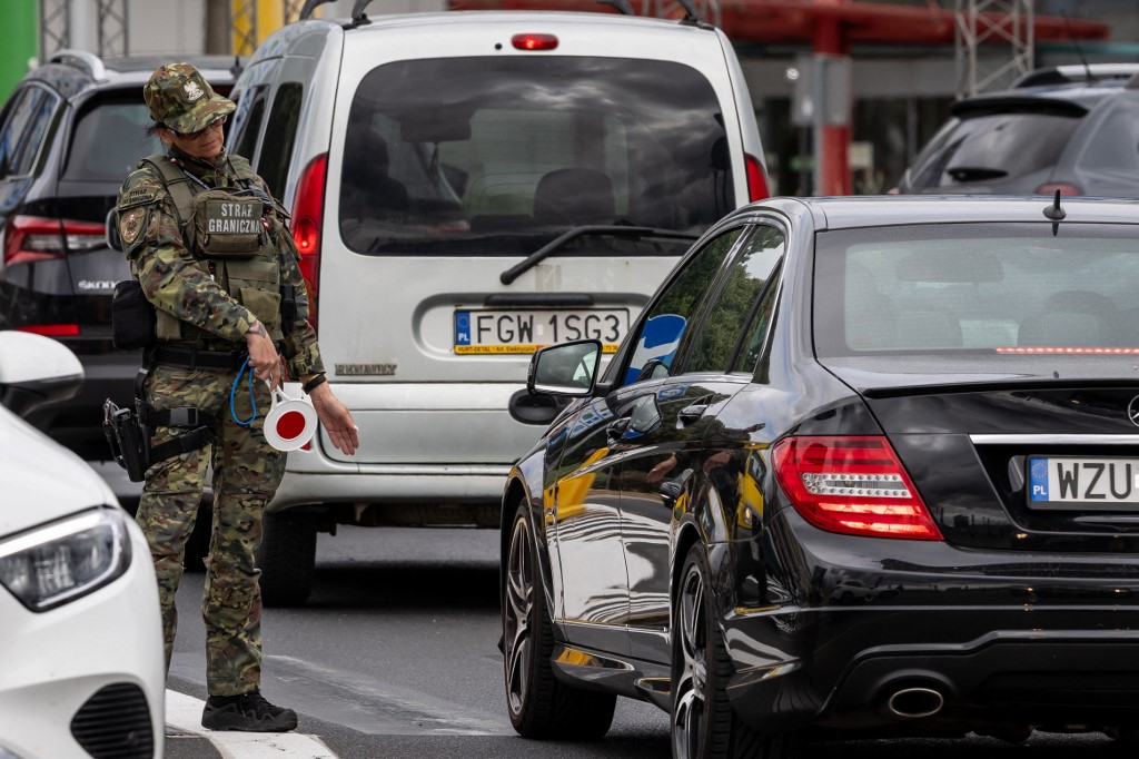 A Polish border guard stops cars for checking at the Polish-German border in Slubice