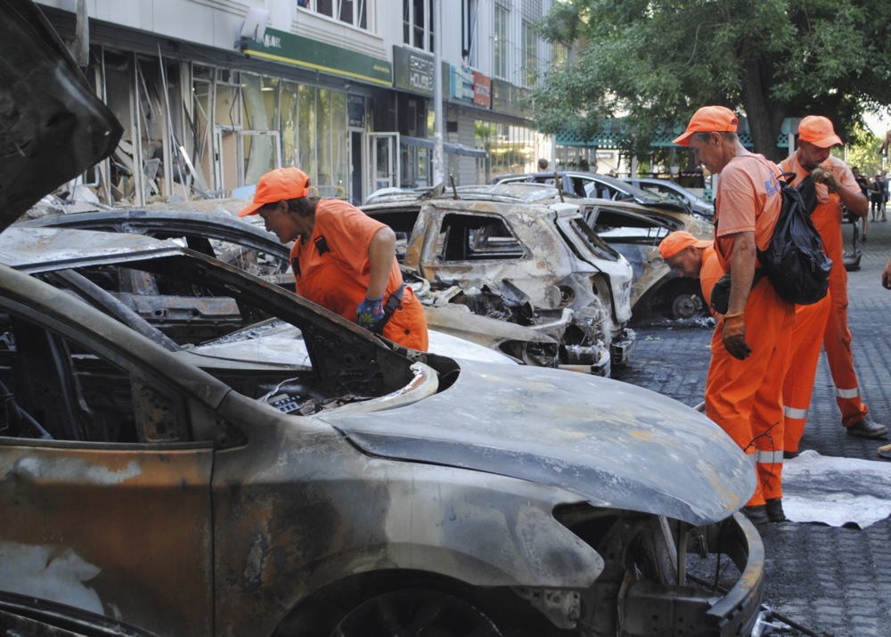 epa12252643 Communal workers work at the site of a drone strike in Odesa, southern Ukraine, 22 July 2025, amid the Russian invasion. At least one person was injured after Russian forces attacked Odesa, the State Emergency Service (SES) of Ukraine reported. As a result of the attack, a residential building, supermarket, sports hall, administrative building, and more than 30 cars were damaged. EPA/IGOR TKACHENKO