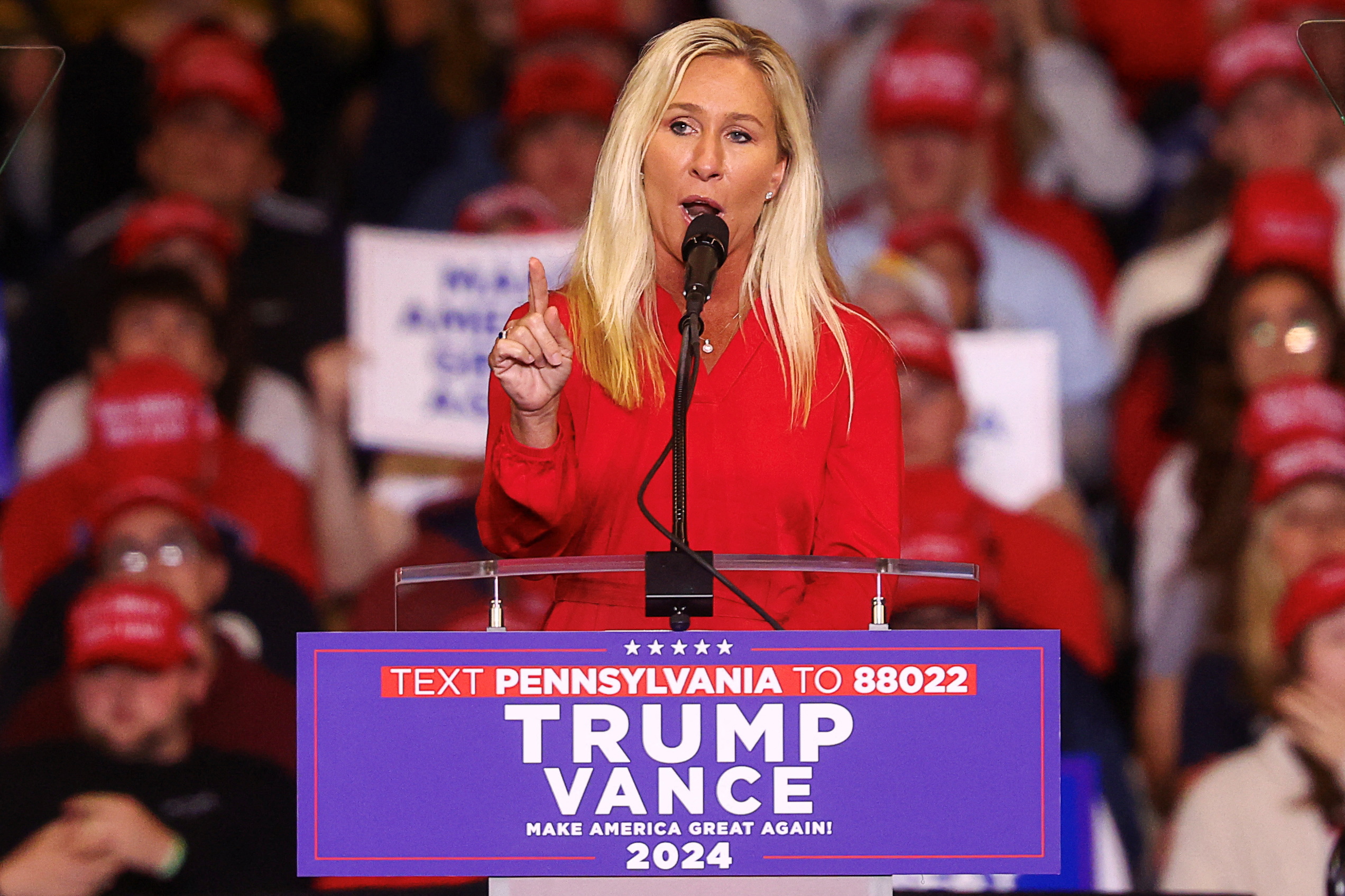 Marjorie Taylor Greene on stage in a red dress