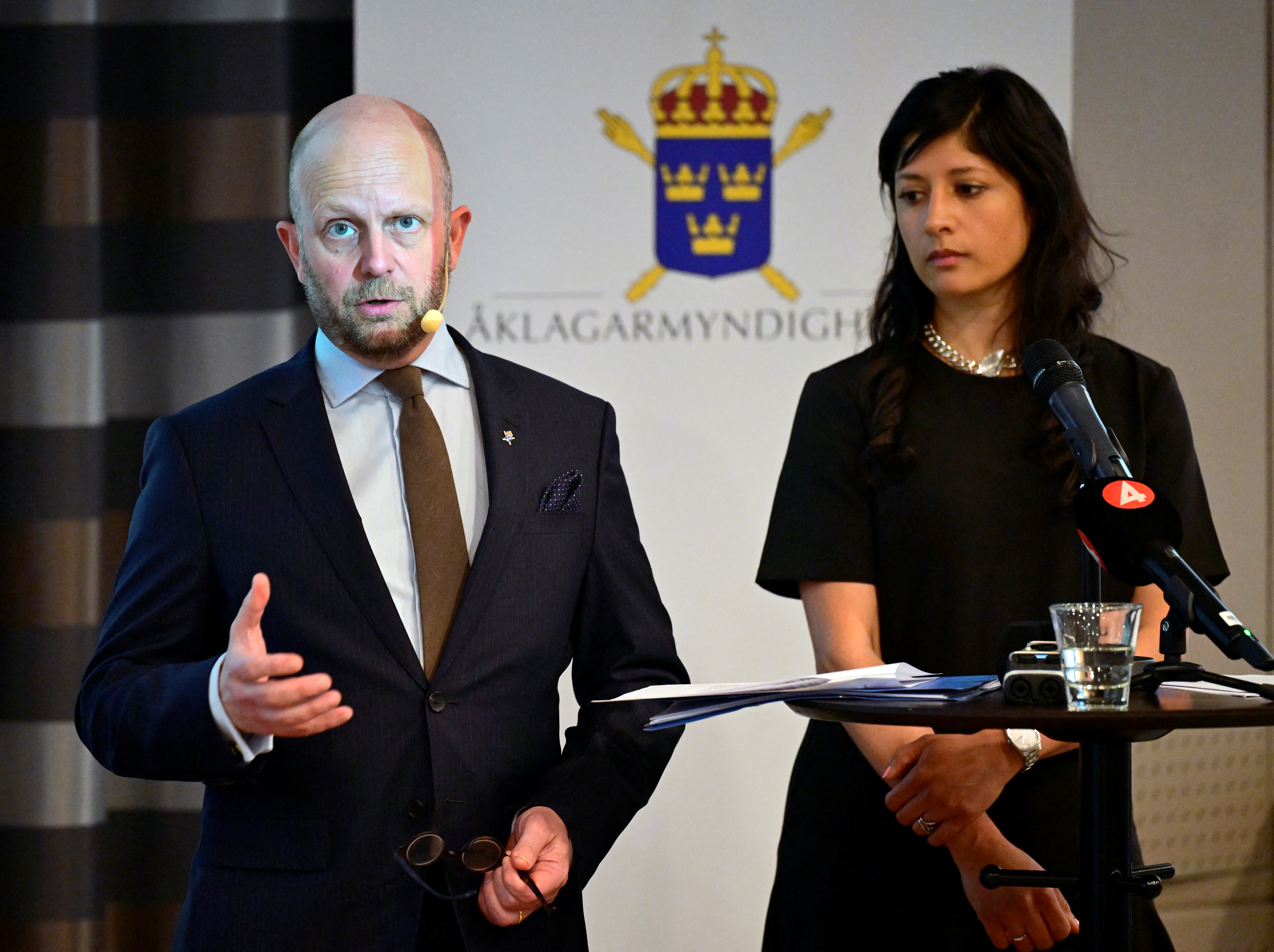 Prosecutors attend a news conference.