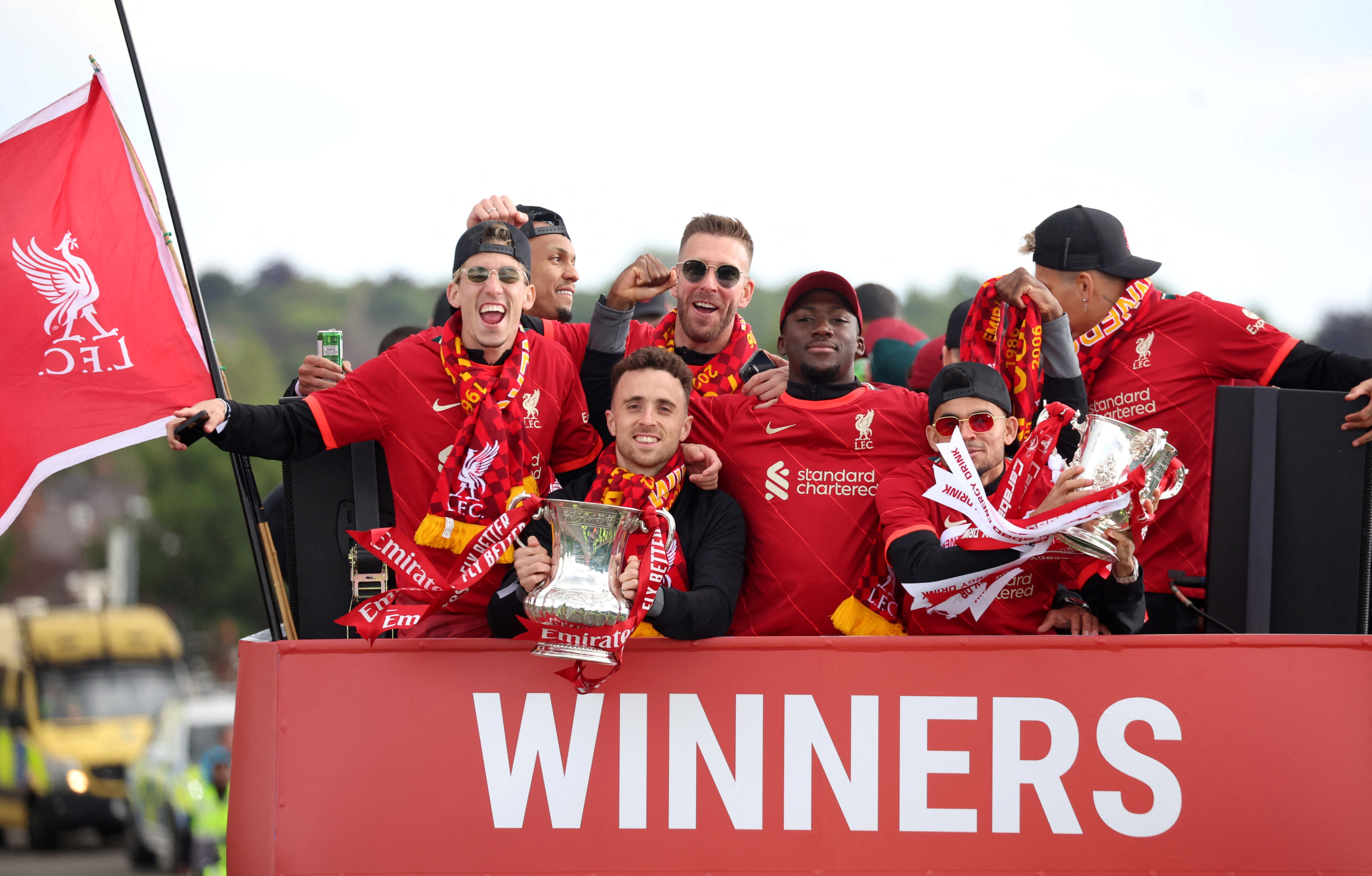 Liverpool's Diogo Jota and Luis Diaz celebrate with the FA Cup and the Carabao Cup trophies during the bus parade