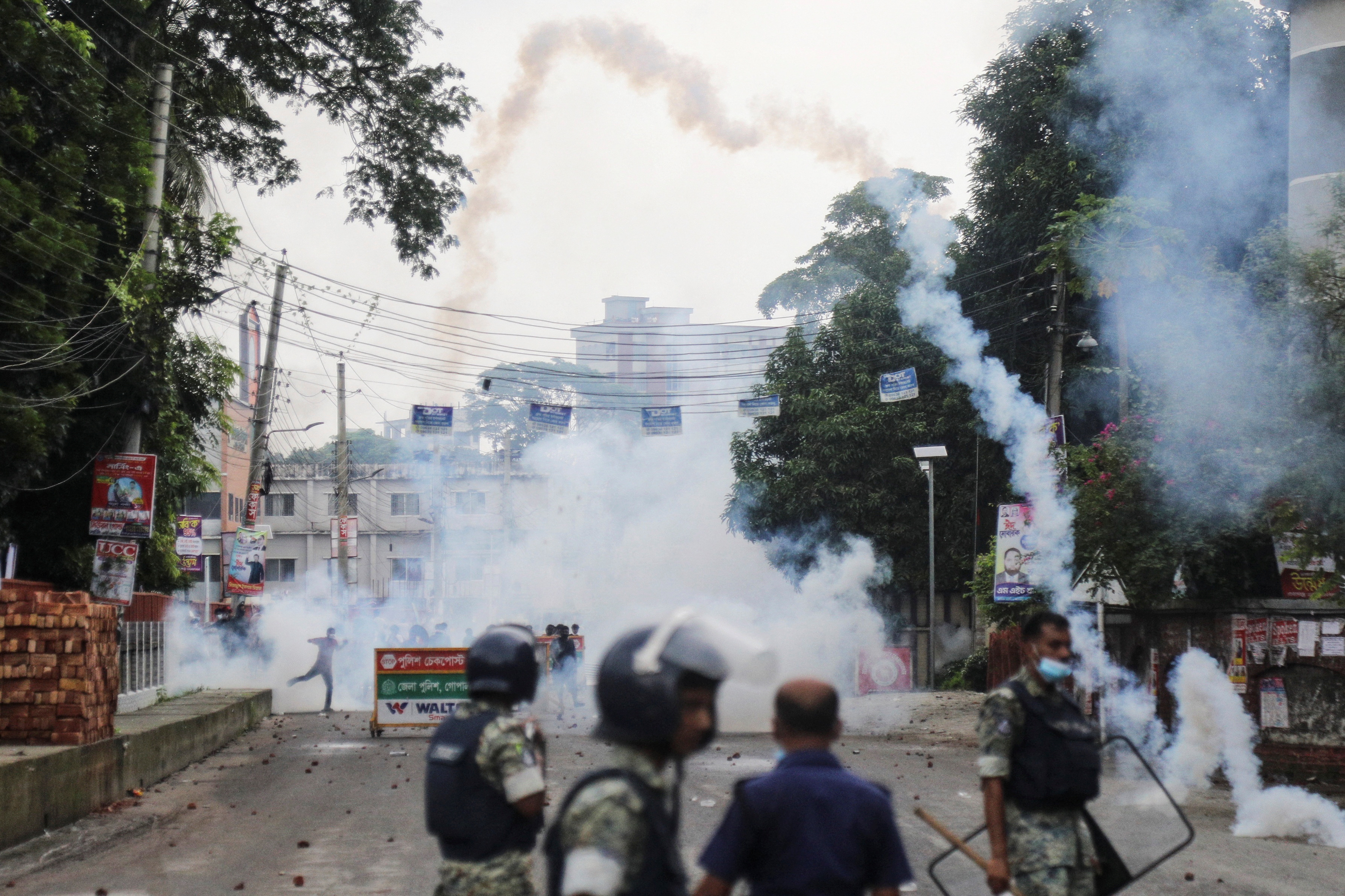 Security forces throw tear gas cans and sound grenades to disperse the Awami League supporters following clashes in Gopalganj, Bangladesh