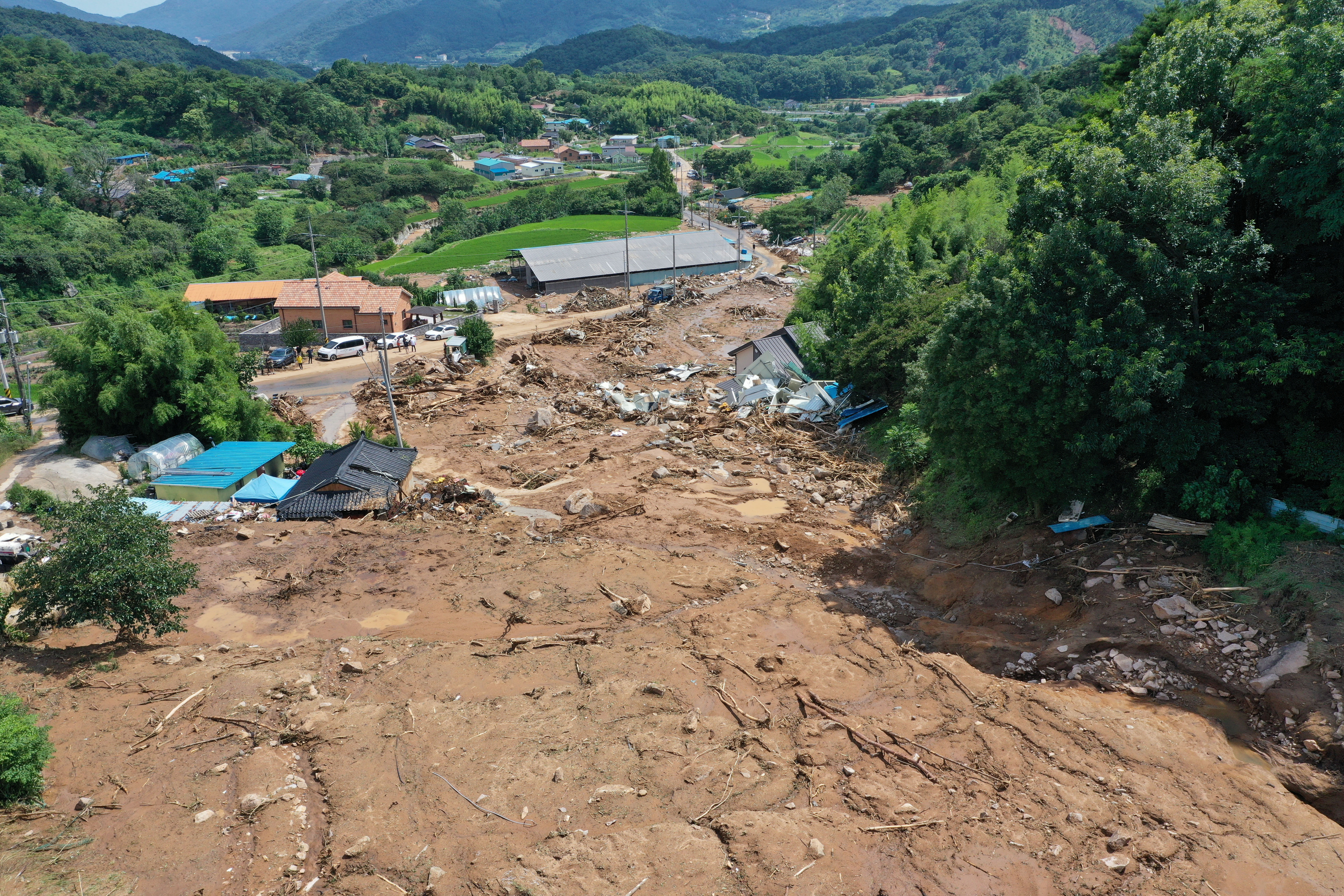 a view of a flooded village with torrents of brown water