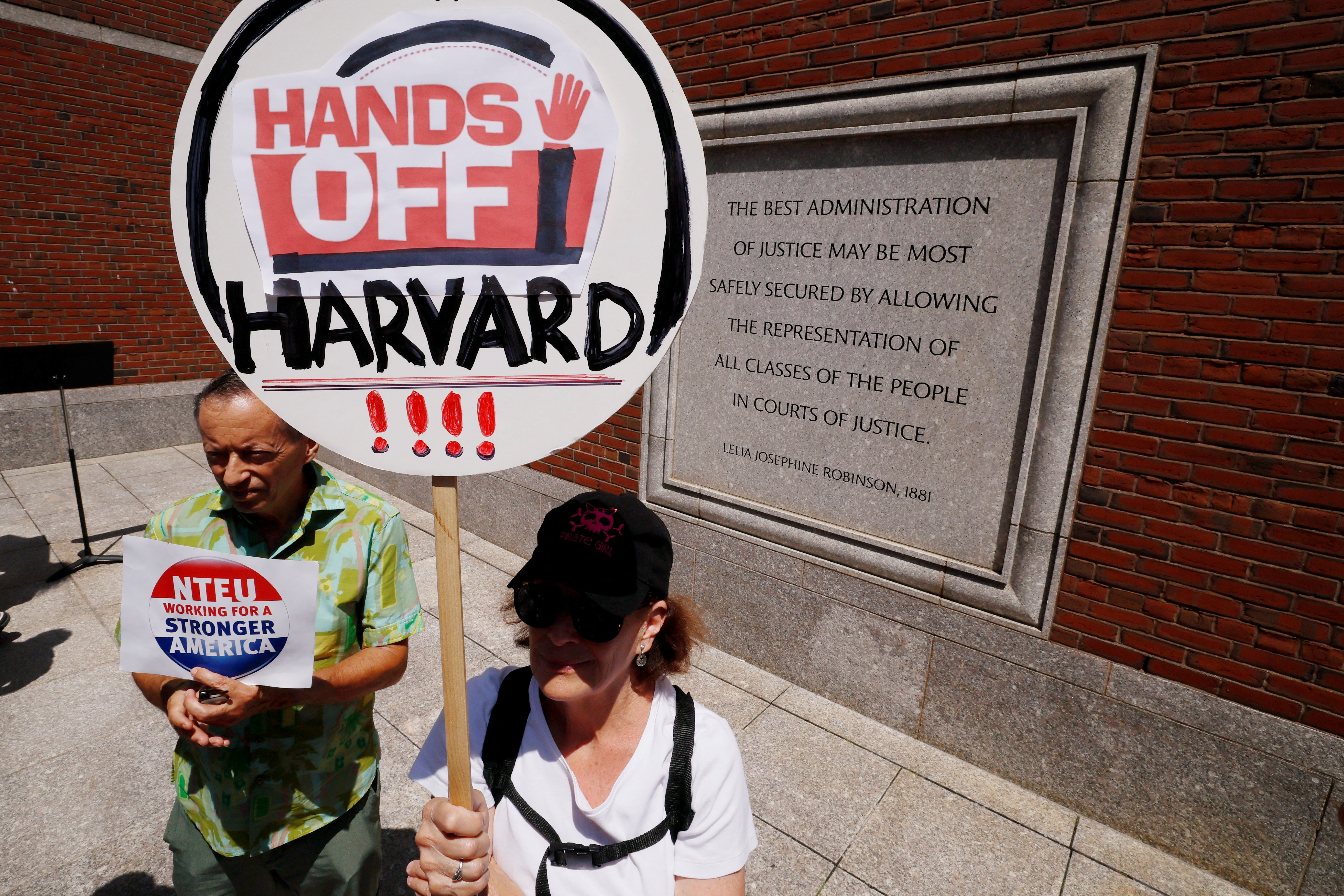 A protester holds up a sign that reads: "Hands off Harvard"