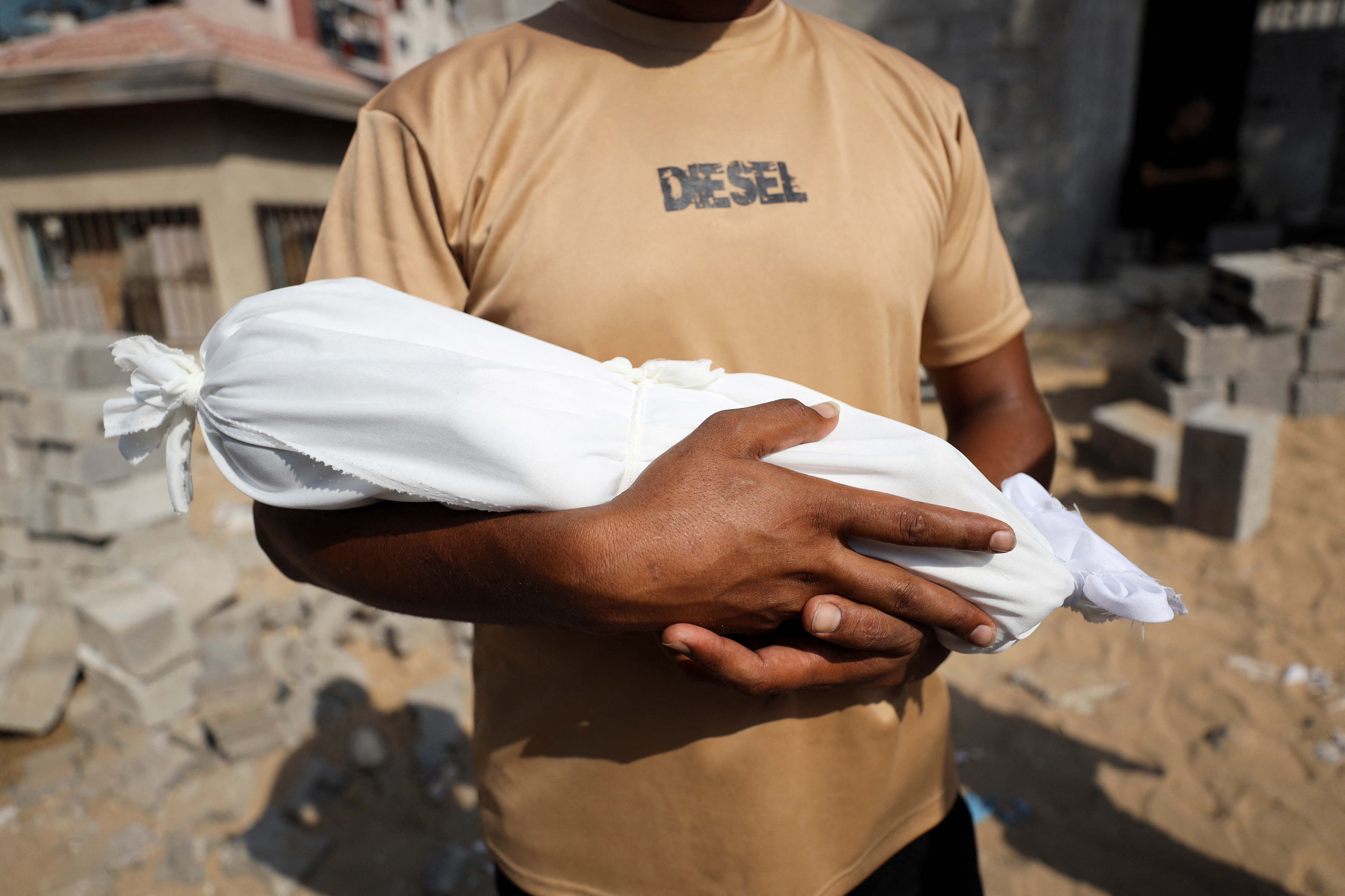 Adham carries the body of his nephew, six-week-old infant Yousef al-Safadi, who died of starvation.