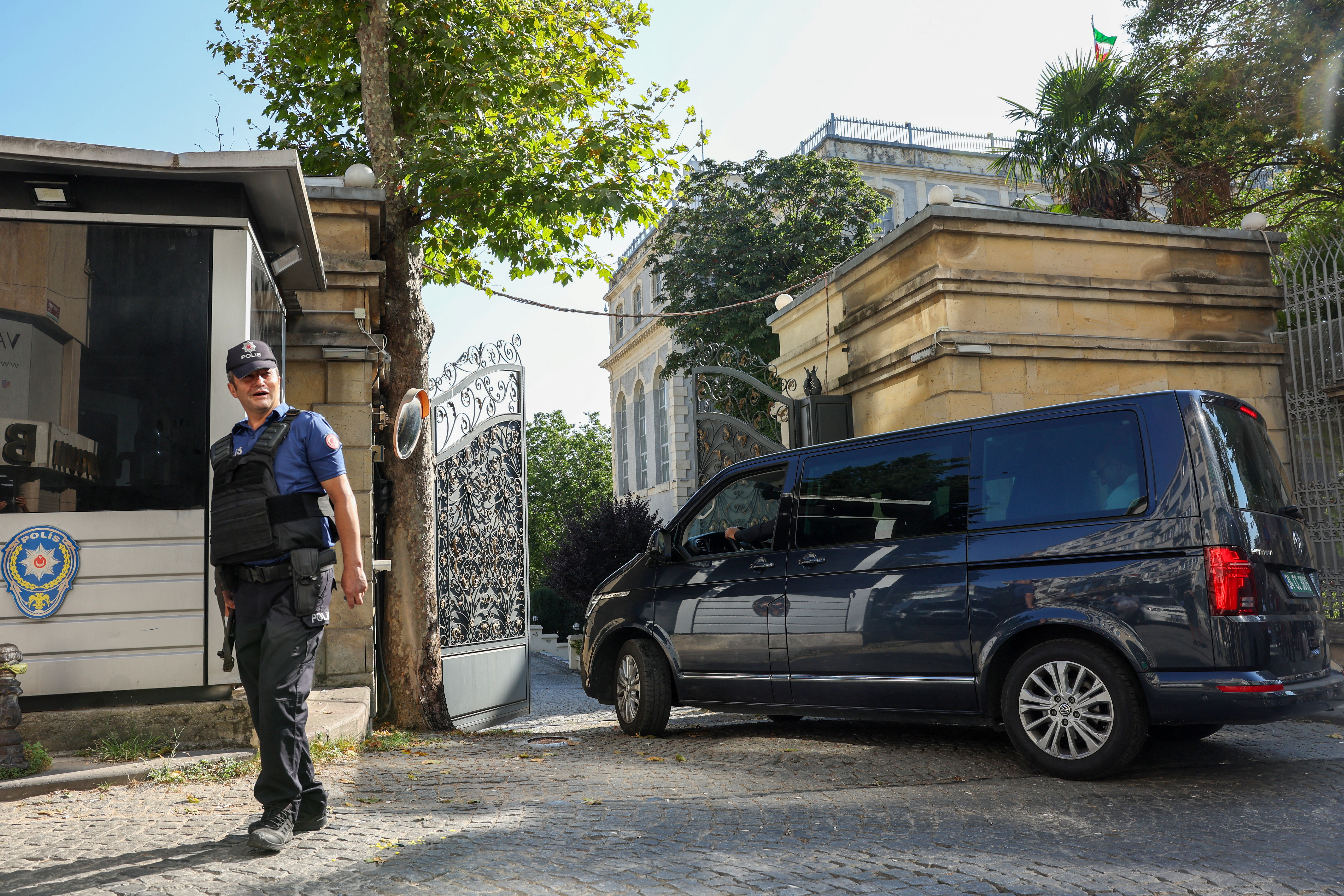 A Turkish policeman stands guard as a vehicle enters the Iranian consulate.