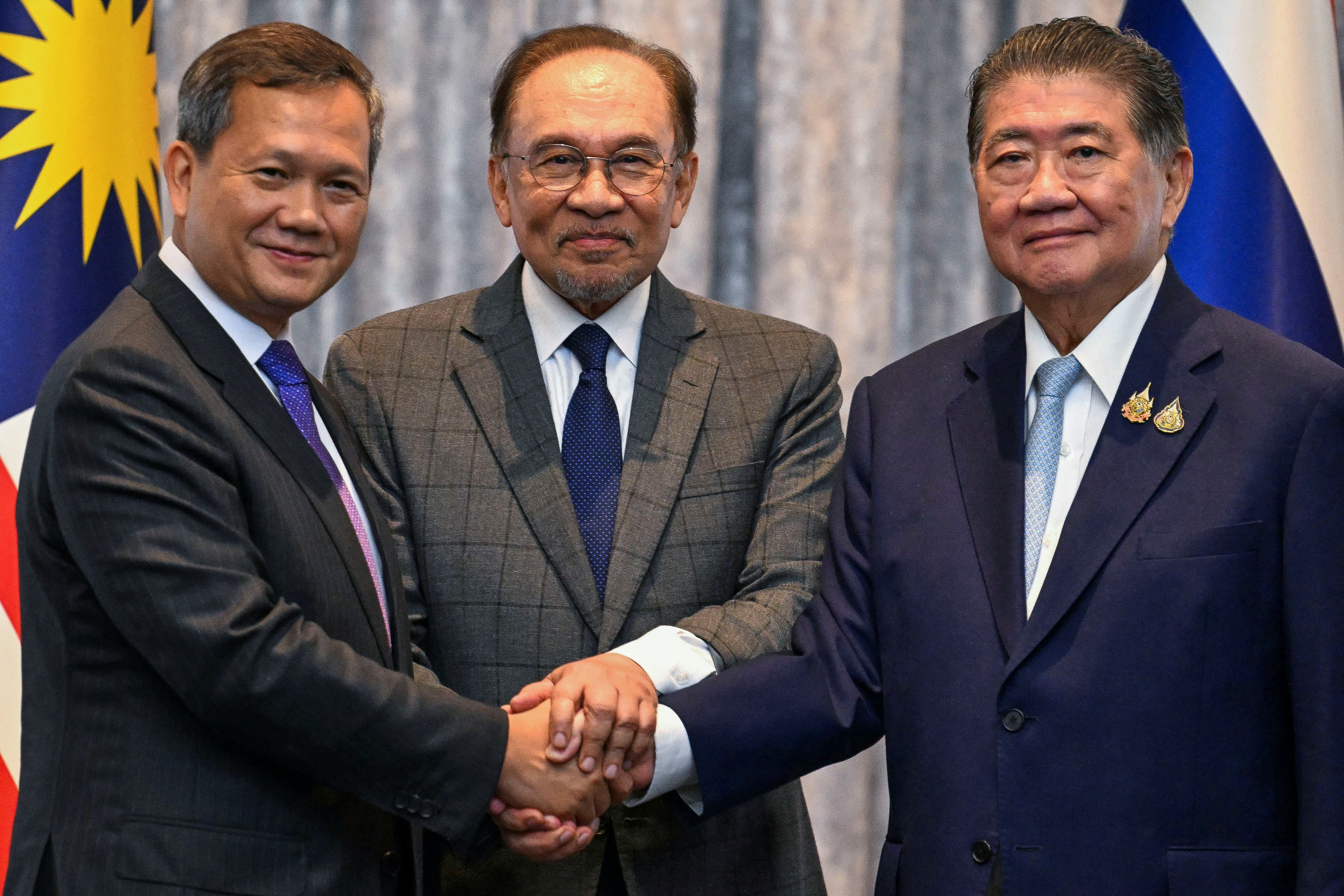 Cambodia's Prime Minister Hun Manet, Malaysia's Prime Minister Anwar Ibrahim and Thailand's acting Prime Minister Phumtham Wechayachai shake hands as they pose for photos following a press conference, on the day of mediation talks on the Thailand–Cambodia border conflict, in Putrajaya, Malaysia July 28, 2025. Mohd Rasfan/Pool via REUTERS
