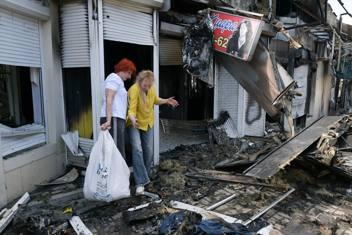 women walk out of a destroyed shop
