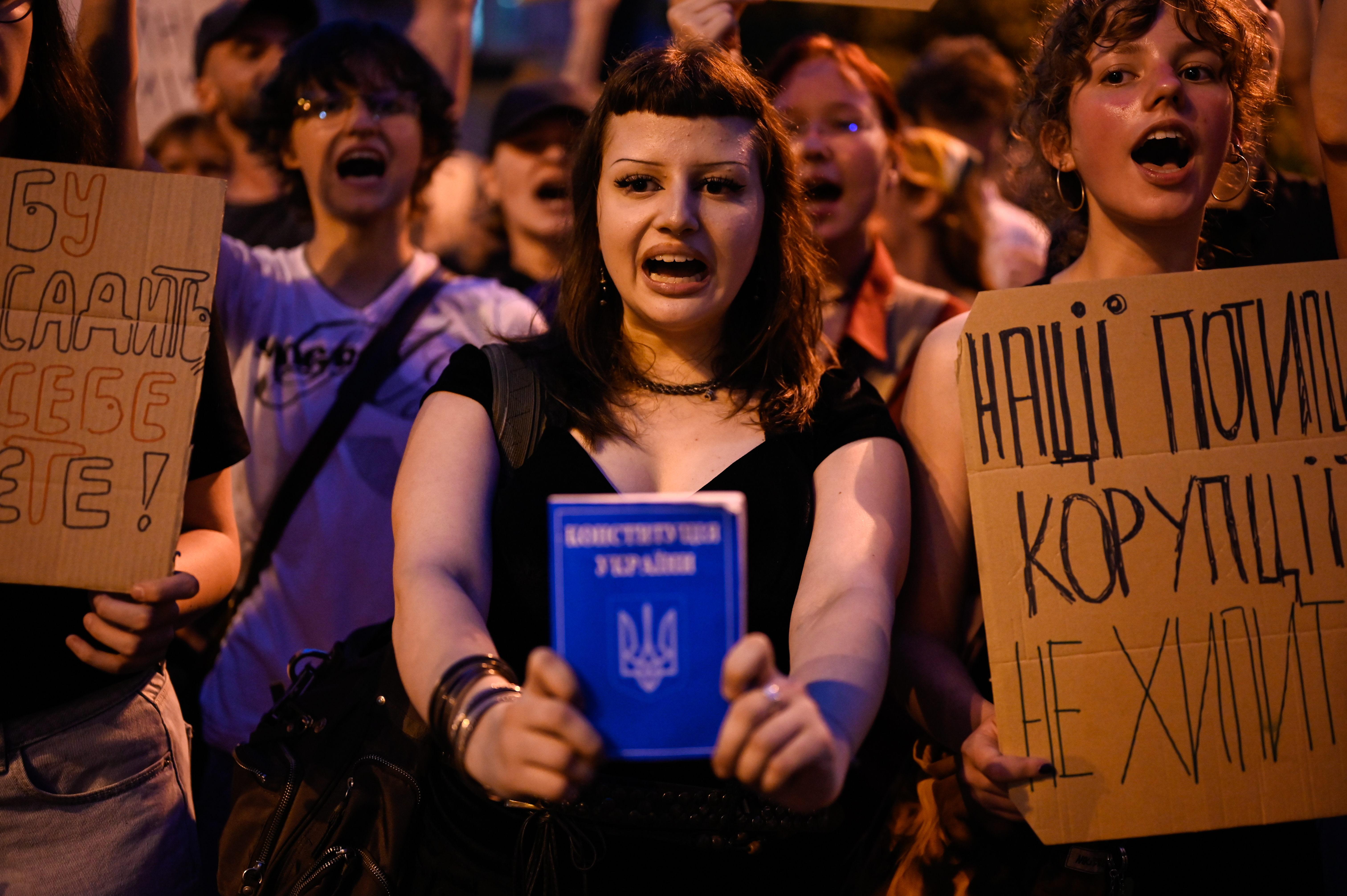 A protestor in Kyiv holds up a book, protesting against Zelenskyy's approval of a bill that limits the power of anti-corruption agencies on July 22, 2025.