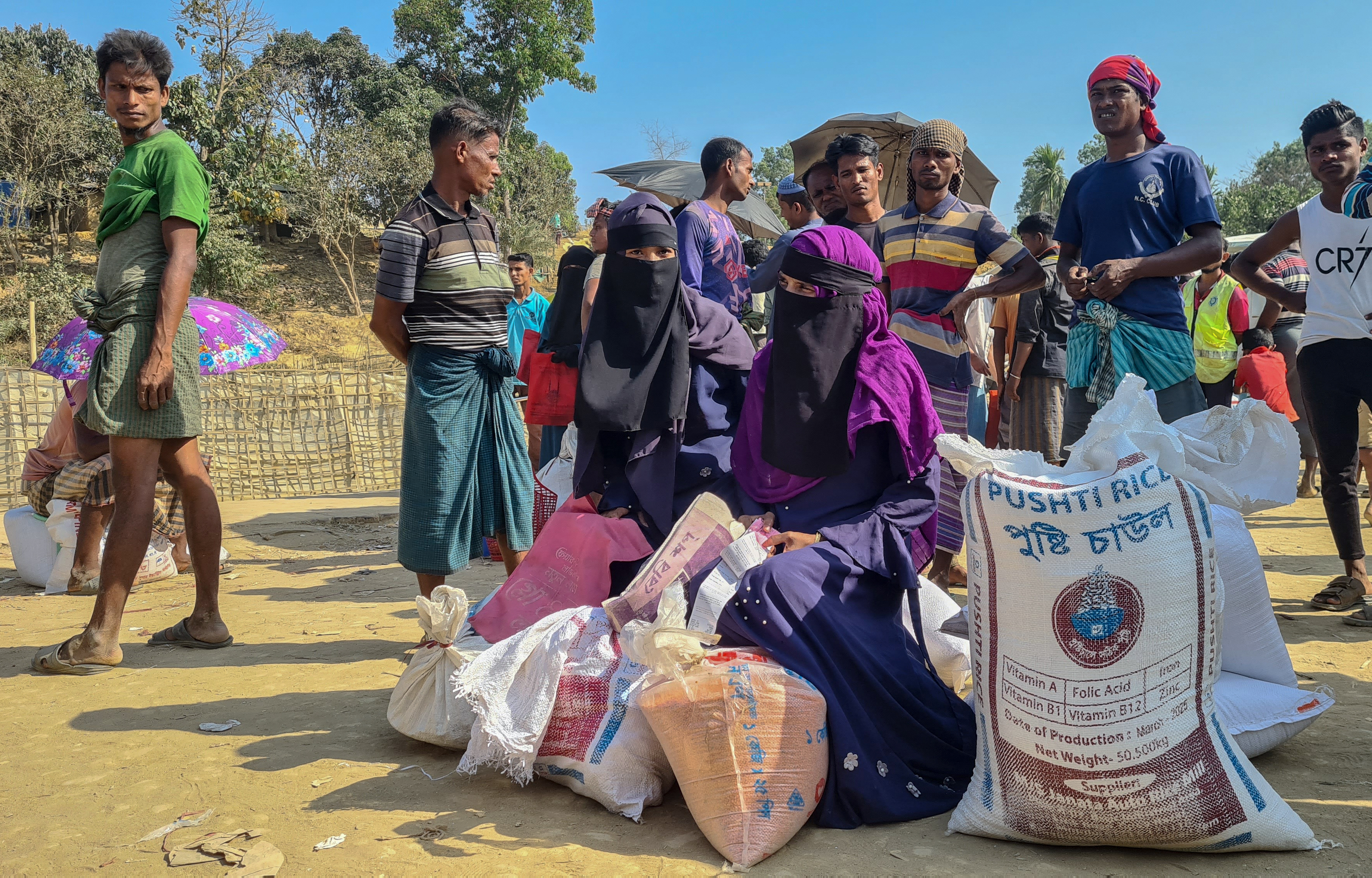 Rohingya refugees gather to collect relief materials from a distribution point in the Kutupalong Refugee Camp in Ukhia in Bangladesh's Cox's Bazar district on March 6, 2025.