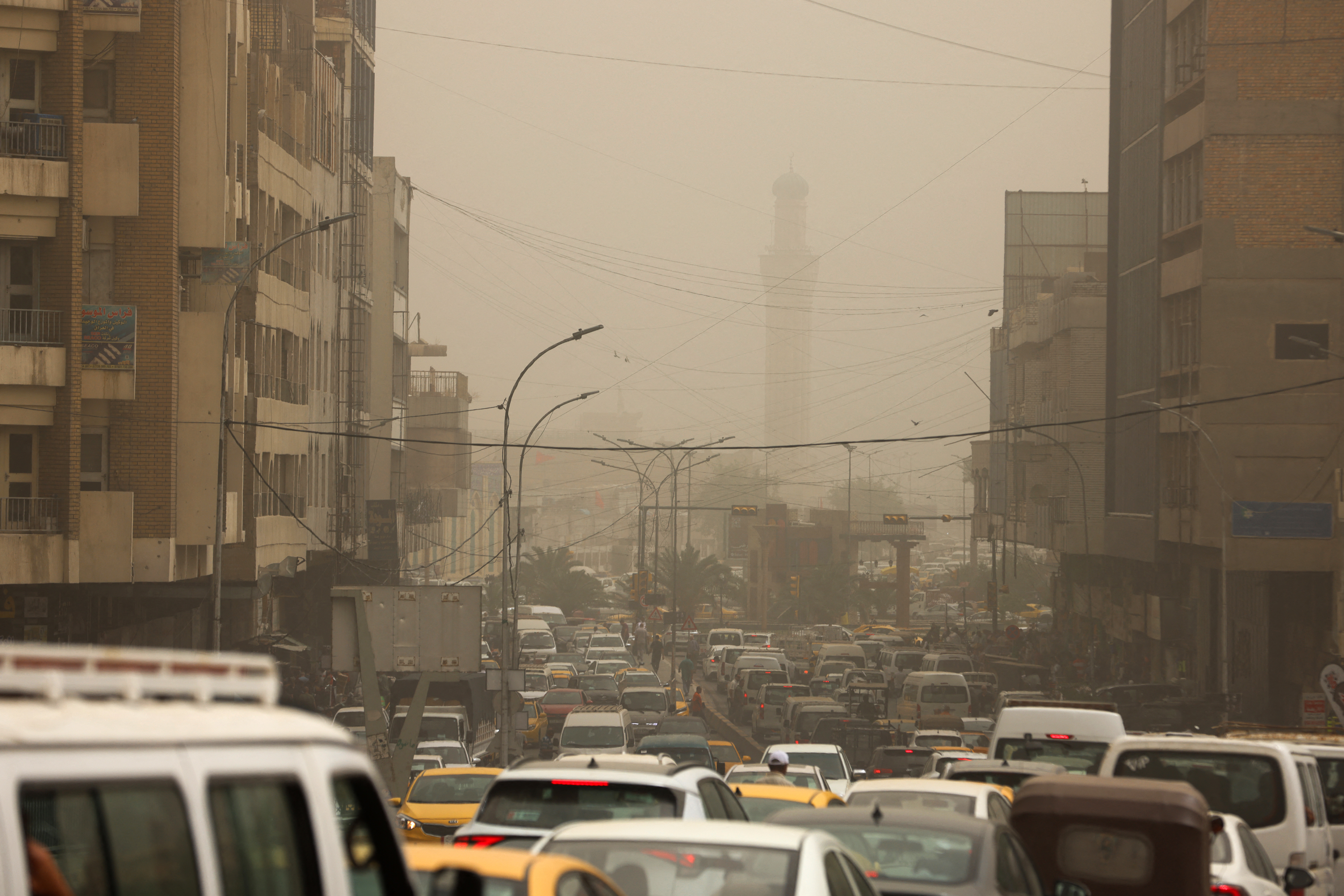 Vehicles are stuck in traffic in al-Senak Square in central Baghdad, Iraq during a dust storm.