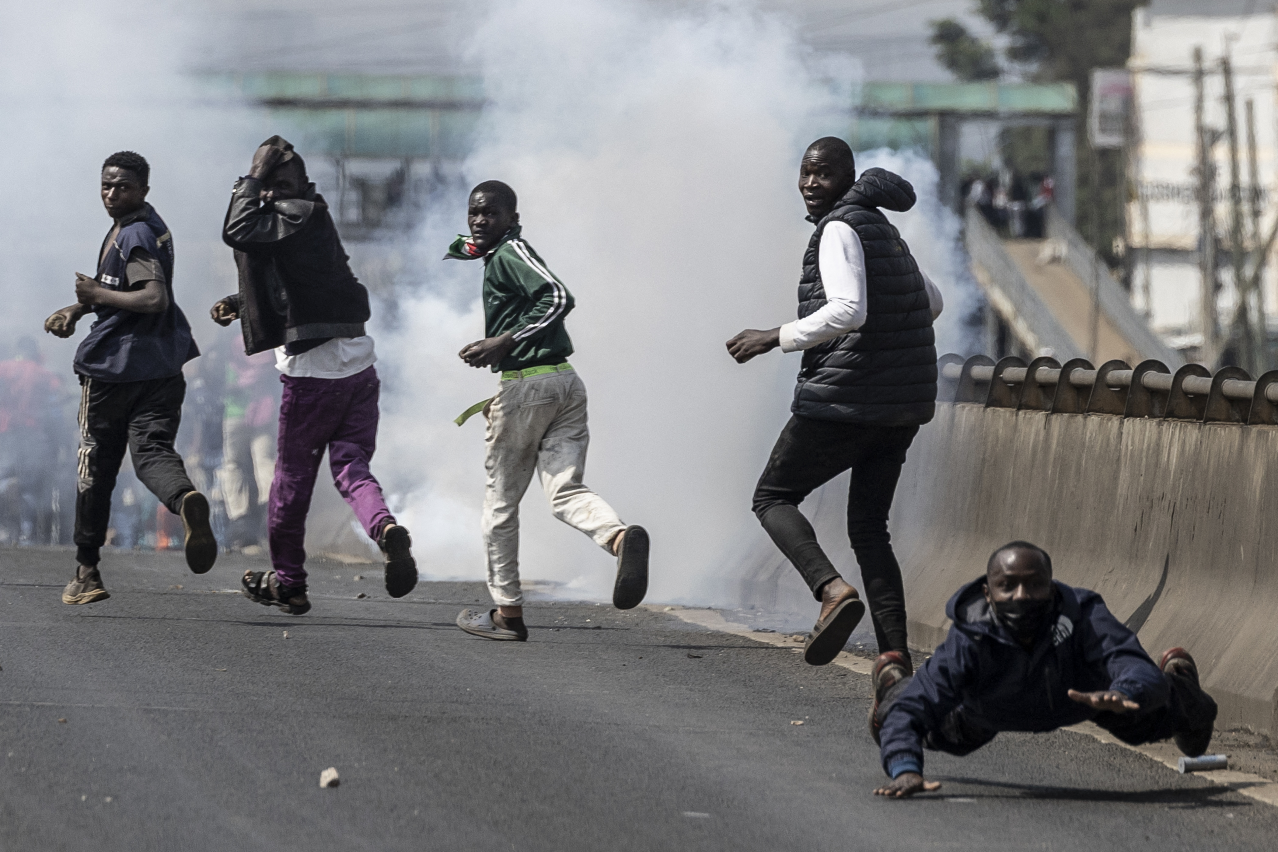 people run away as smoke rises in a street