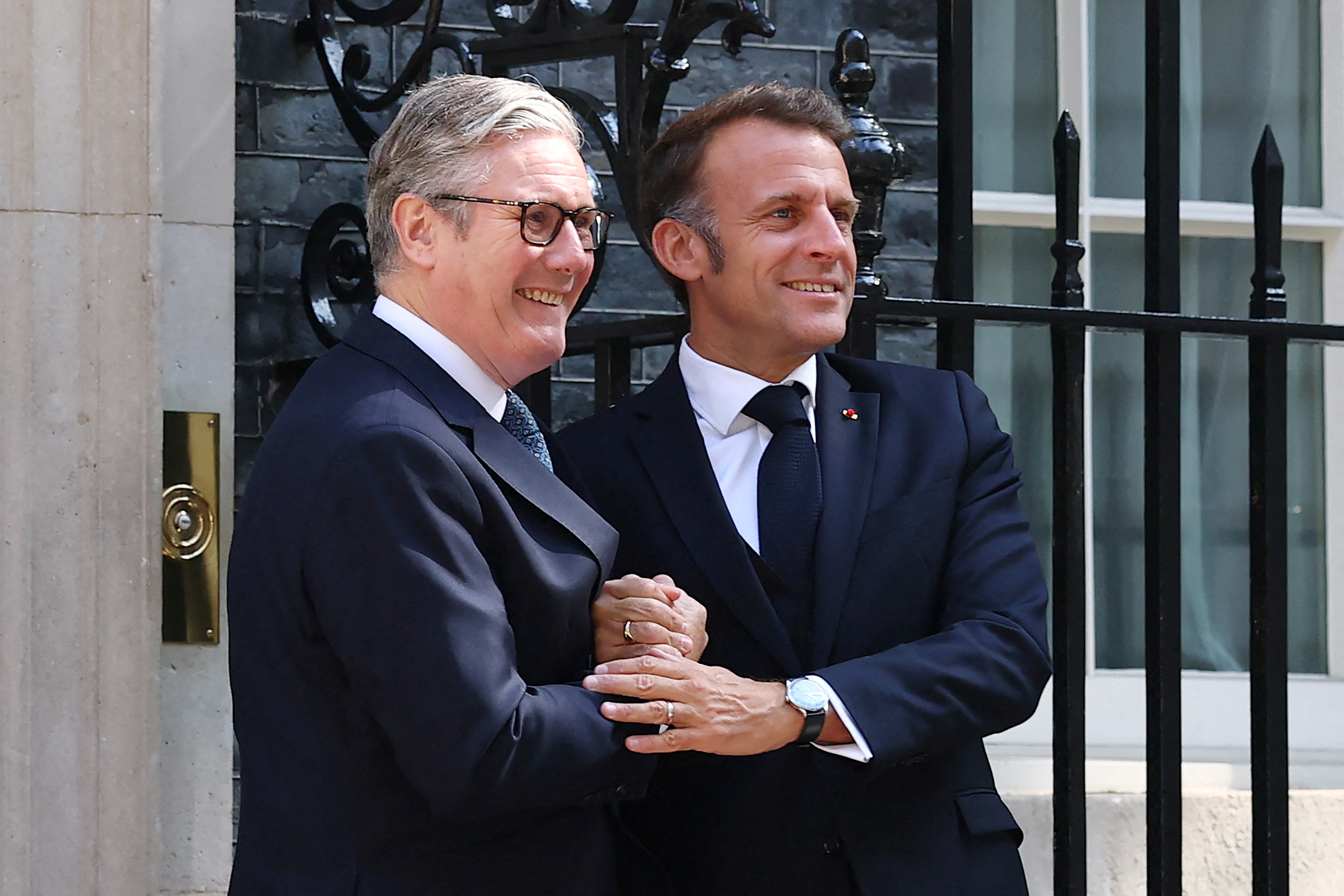 Britain's Prime Minister Keir Starmer (L) shakes hands with France's President Emmanuel Macron.