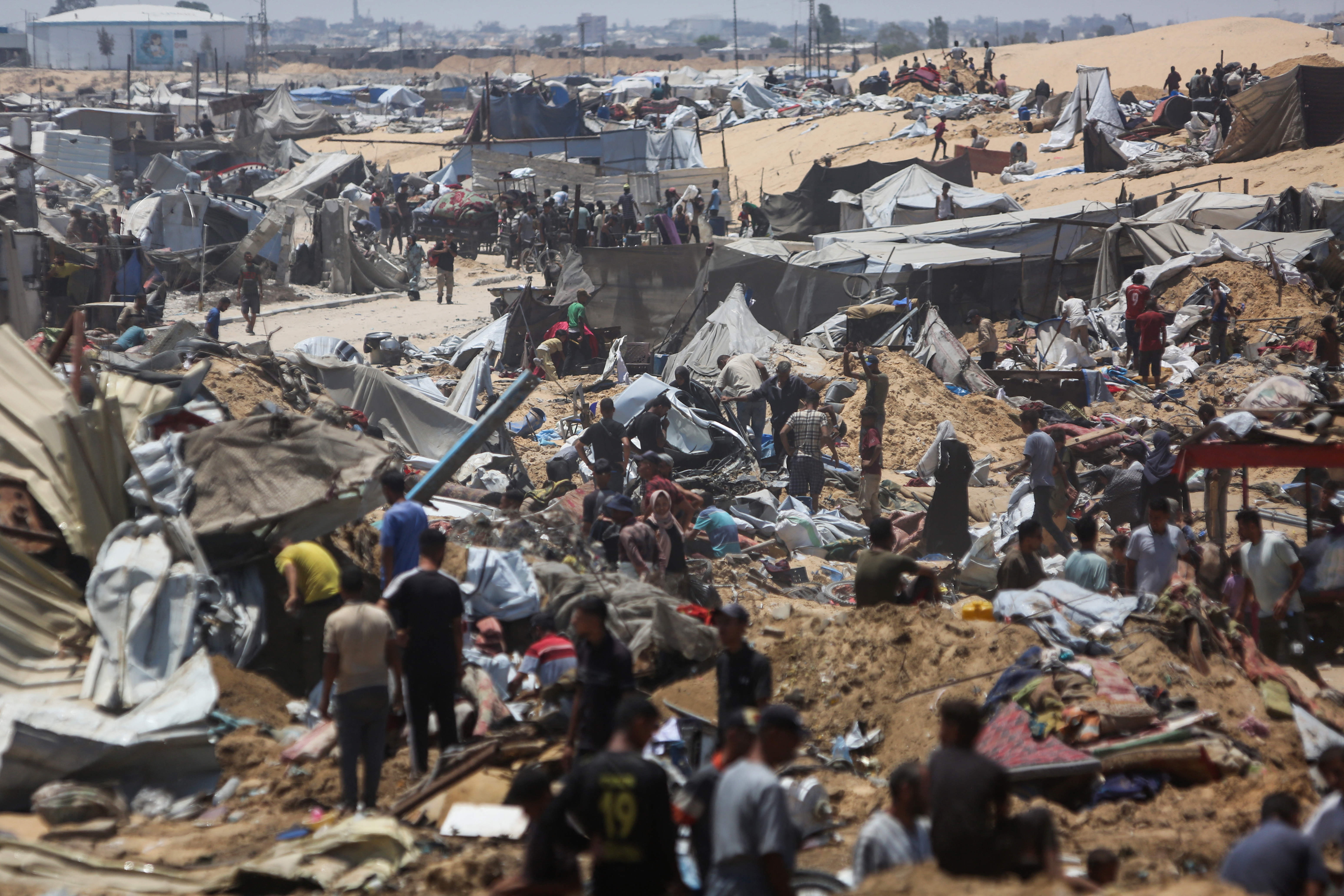 Palestinians inspect the destruction at a makeshift displacement camp following a reported incursion a day earlier by Israeli tanks in the area in Khan Yunis in the southern Gaza