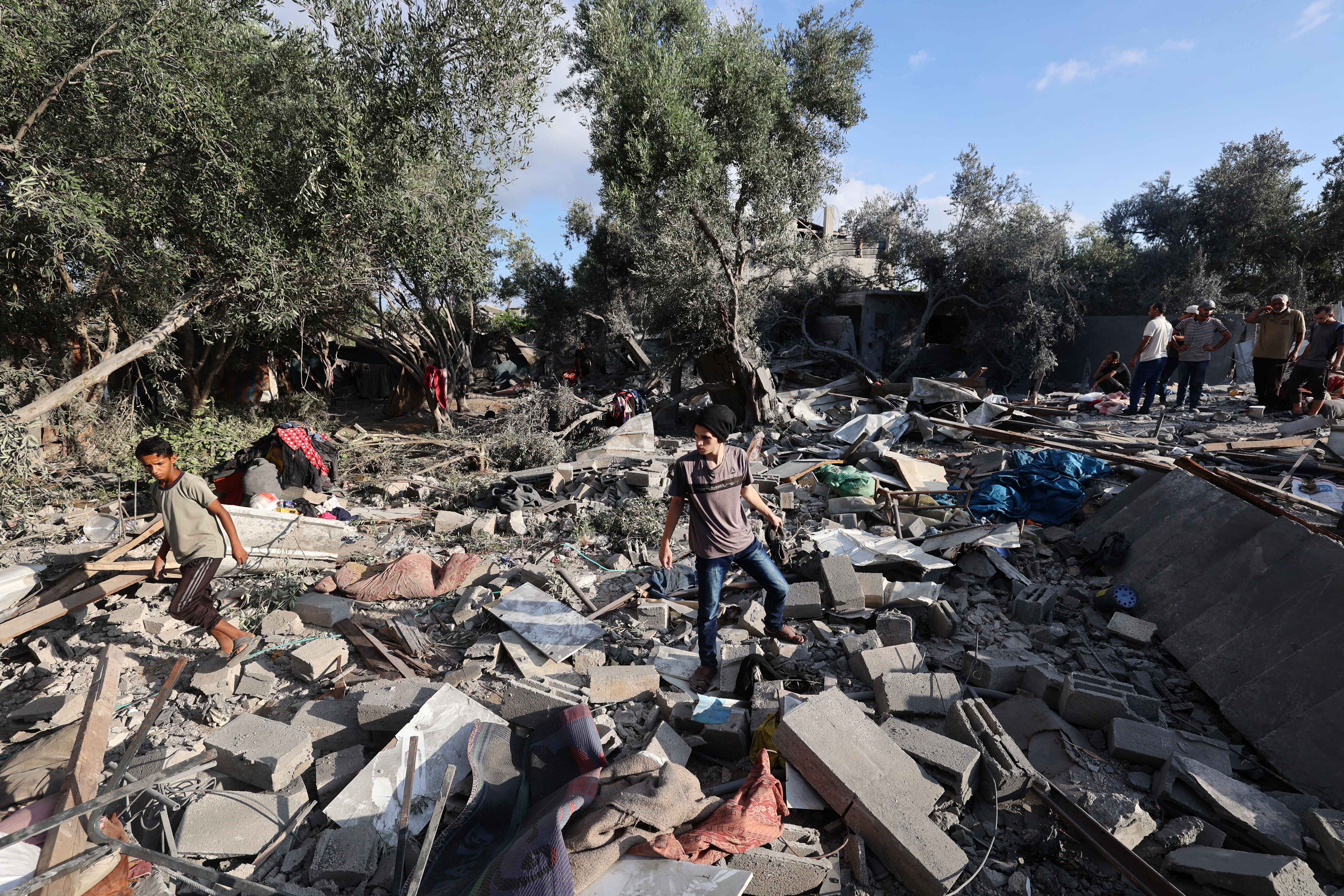 Palestinians assess the damage in the aftermath of an overnight Israeli strike that hit Nuseirat in the central Gaza Strip on July 13, 2025.