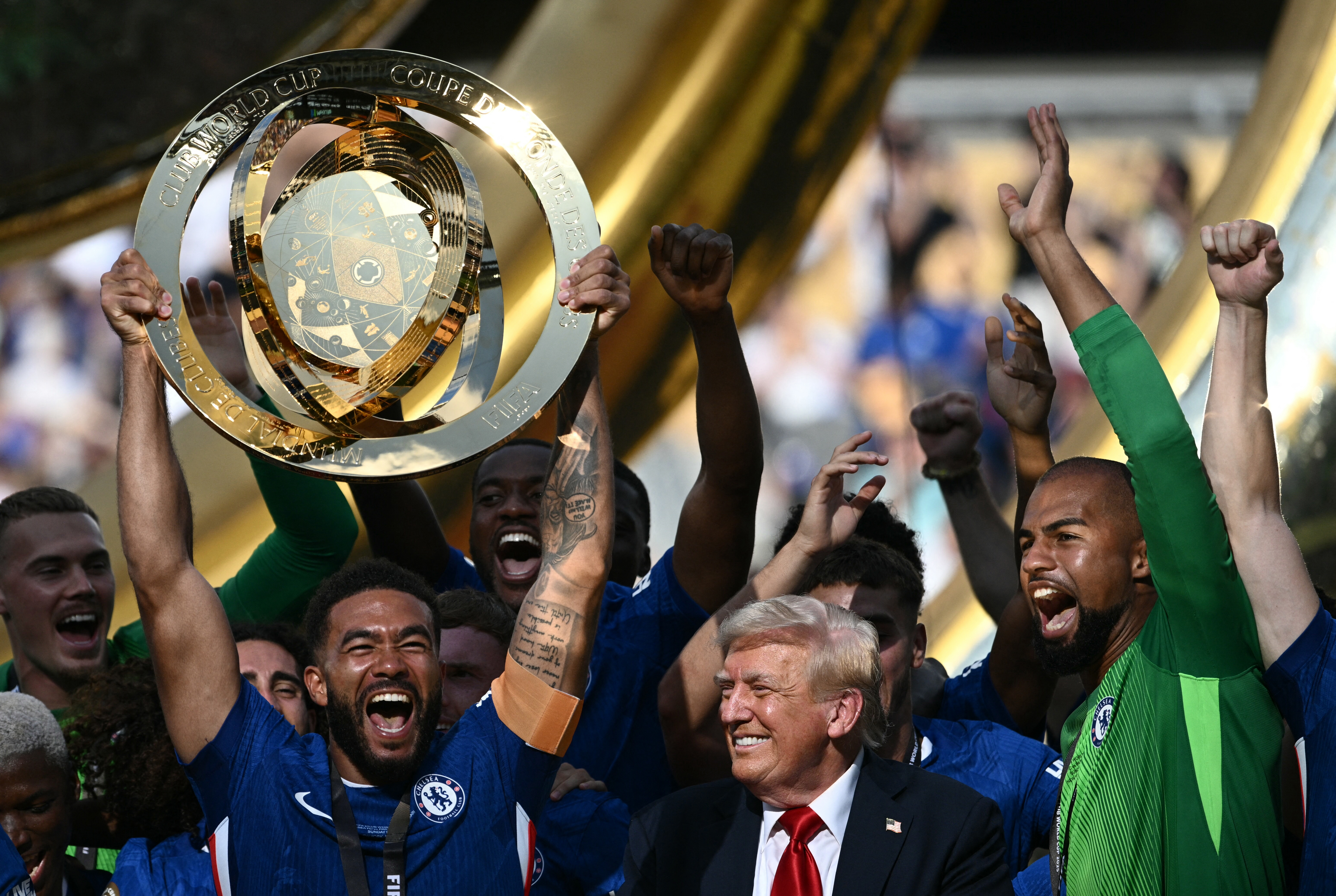 Chelsea's English defender Reece James lifts the trophy as teammates and US President Donald Trump cheer during the award ceremony for the FIFA Club World Cup 2025 Champions