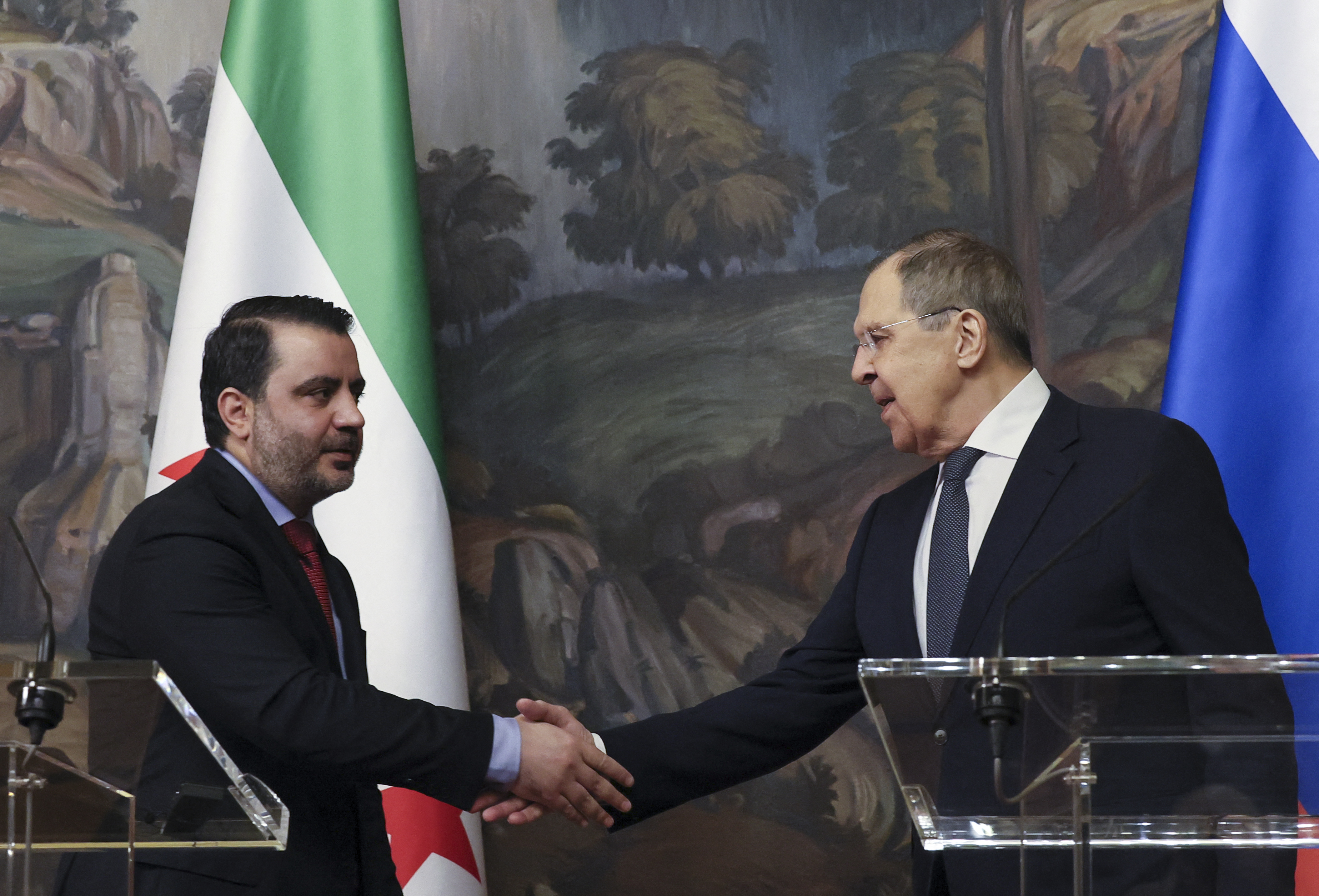 Russian Foreign Minister Sergei Lavrov and Syrian Foreign Minister Asaad al-Shaibani shake hands at the end of a joint press conference following their meeting in Moscow on July 31, 2025.