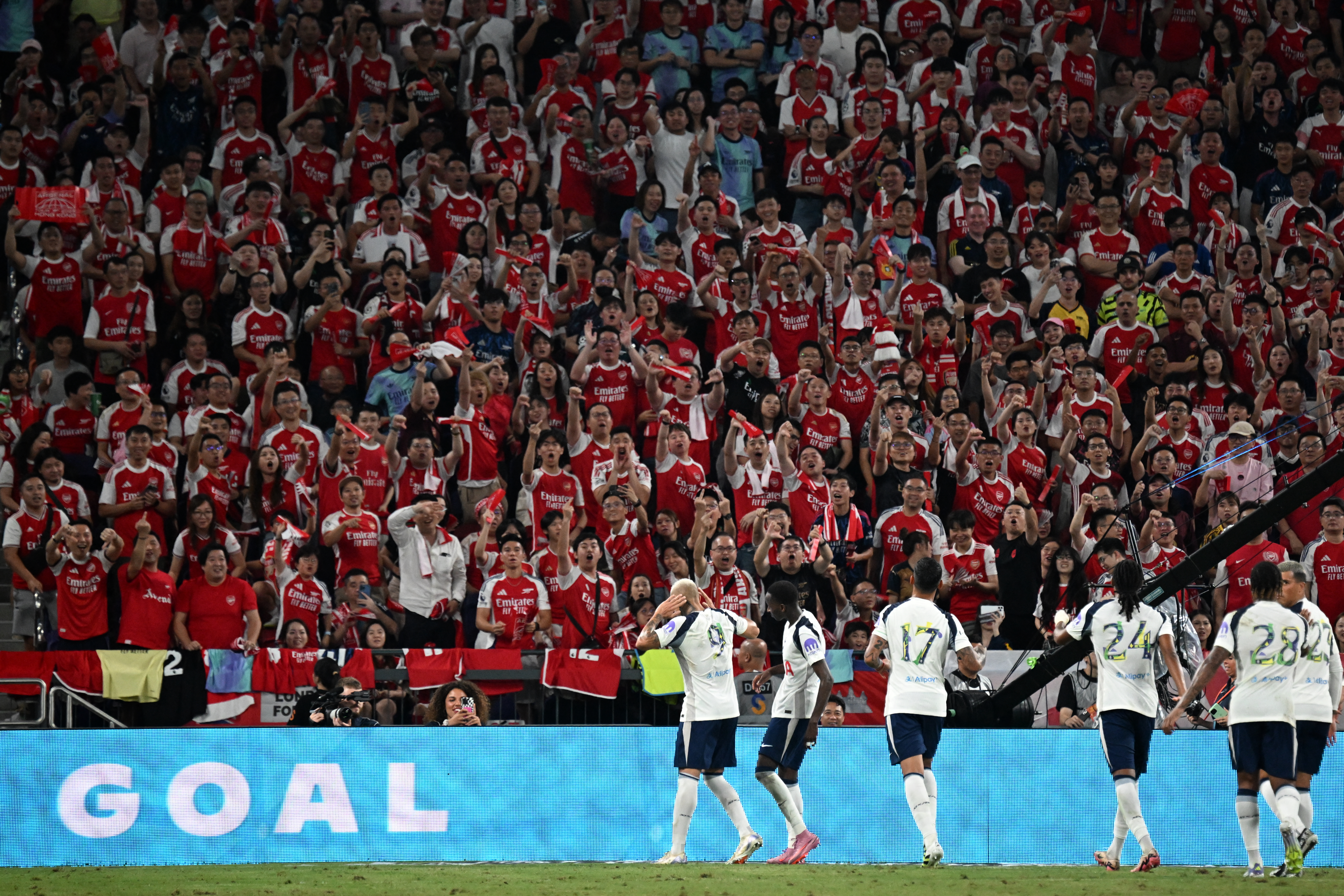 Tottenham Hotspur's players celebrate a goal in front of Arsenal fans 