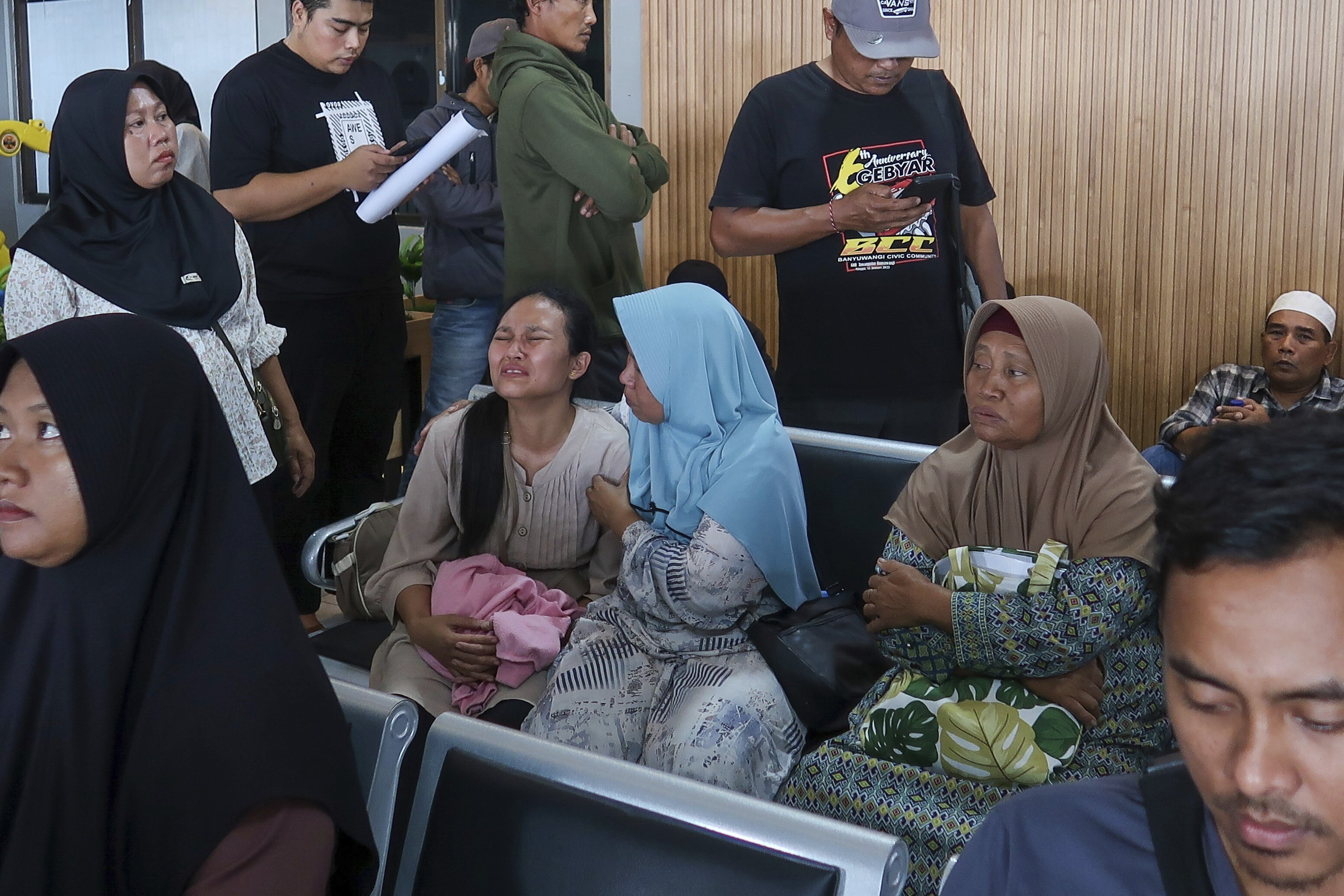 A passenger's relative weeps after a ferry carrying dozens of passengers sank near the resort island of Bali