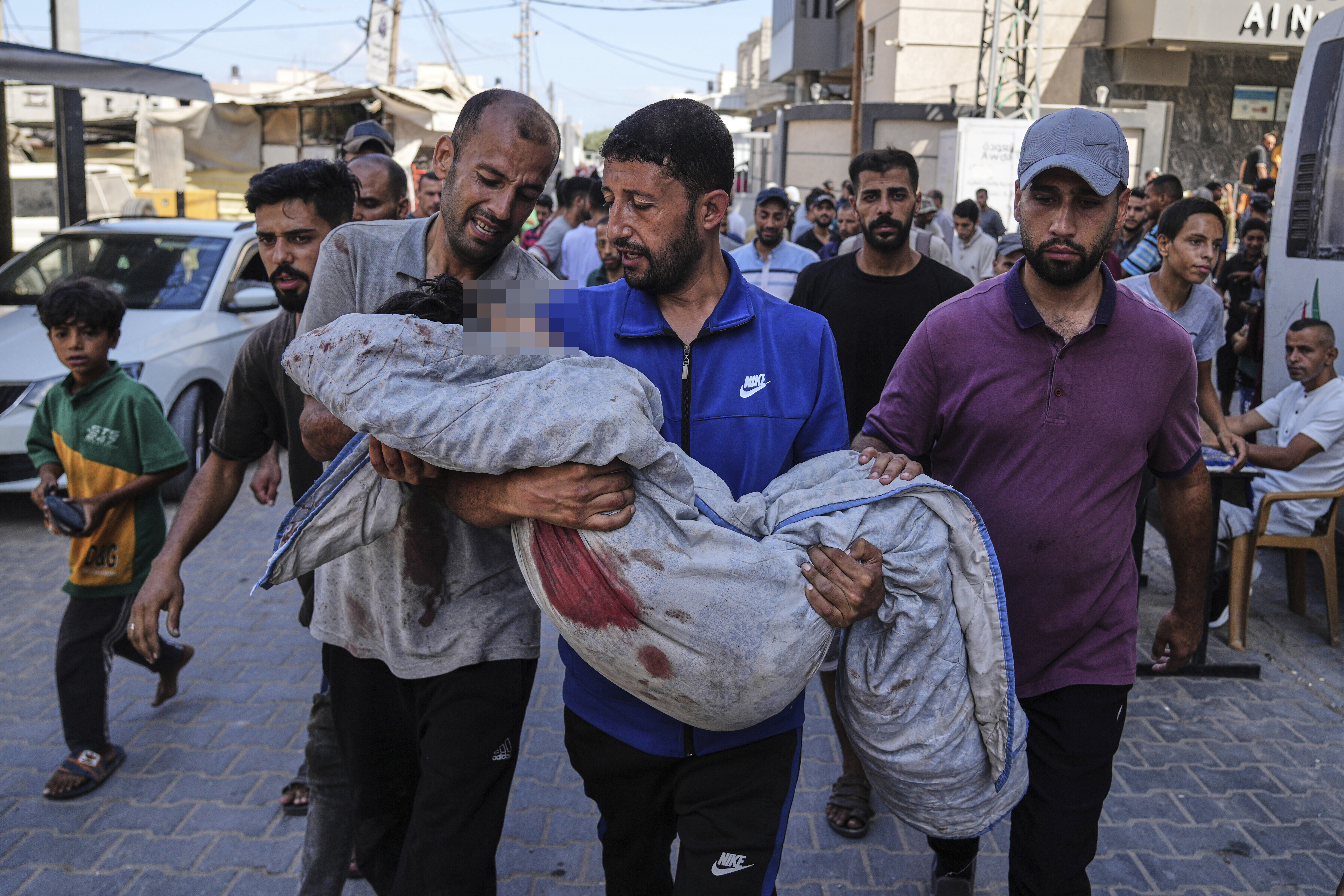 Relatives carry the body of 13-year-old Seraje Ebrahim, killed in an Israeli strike on a drinking water distribution point, for burial outside Al-Awda Hospital in Nuseirat, central Gaza Strip, Sunday, July 13, 2025. [Abdel Kareem Hana/AP]