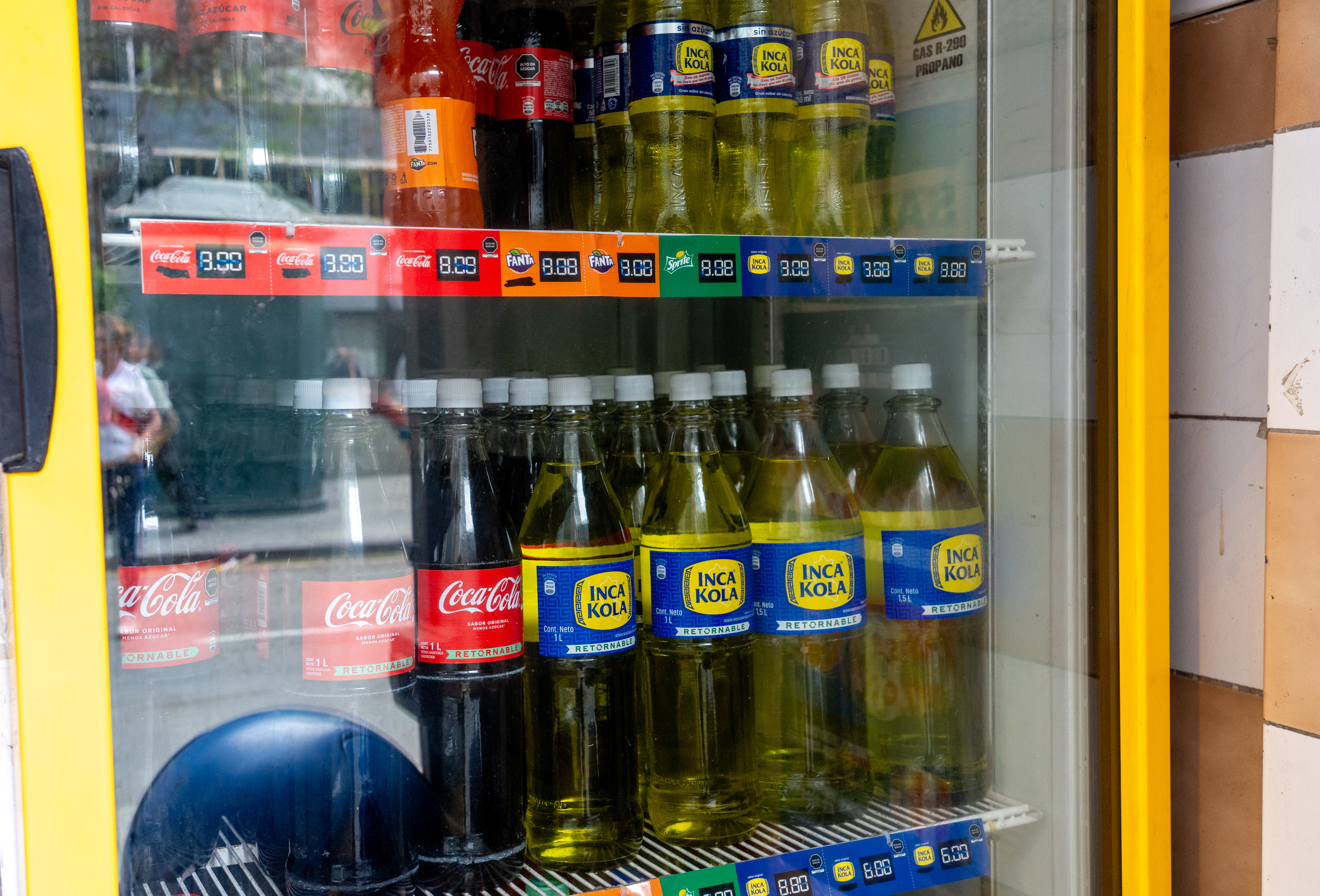 Coca-Cola and Inca Kola bottles sit side by side in a store refrigerator in Lima, Peru.