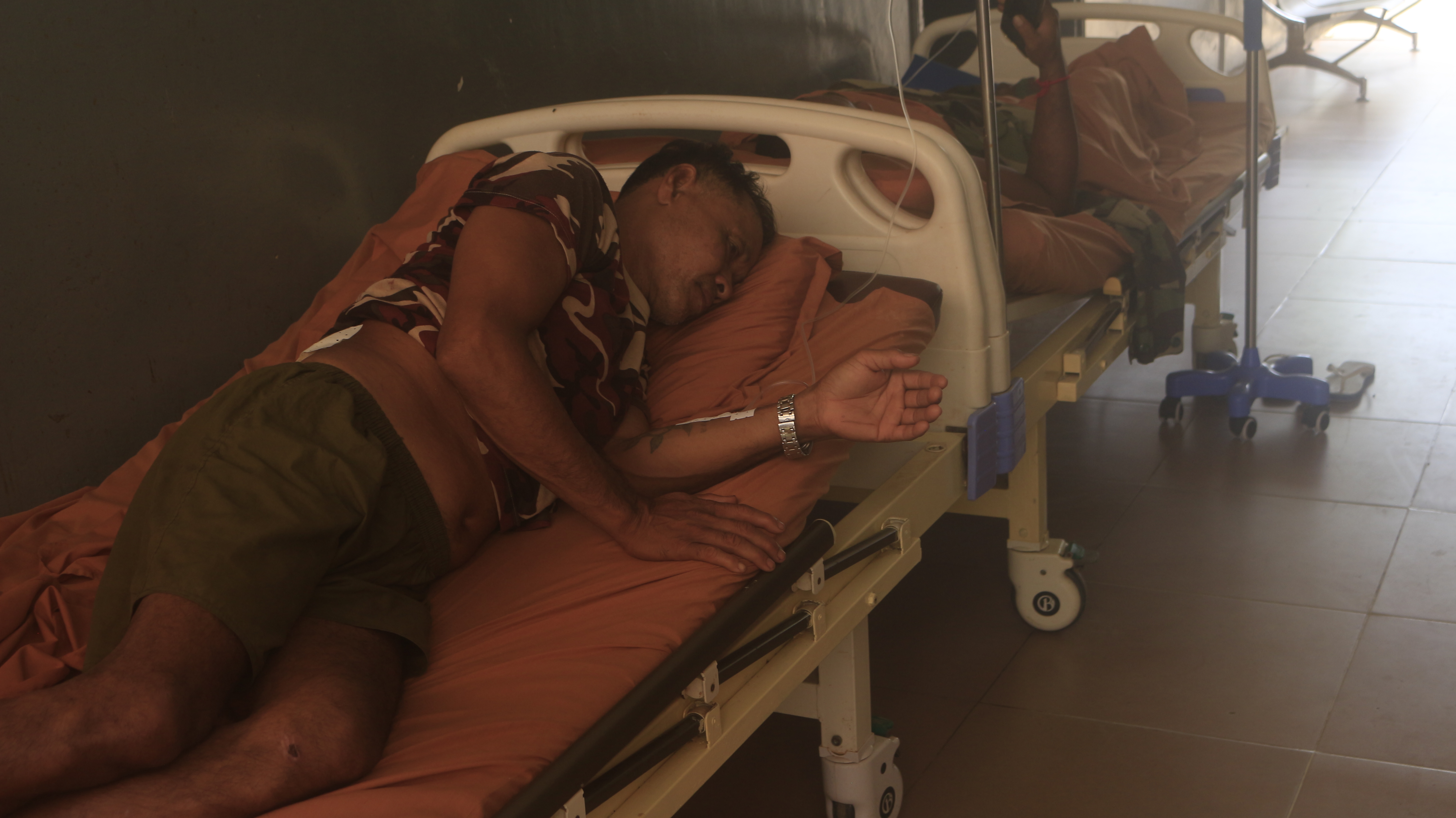 Injured Cambodian soldiers wait in a hospital corridor to receive treatment in Cambodia's Oddar Meanchey province on Friday [Toby Hobbs/Al Jazeera]