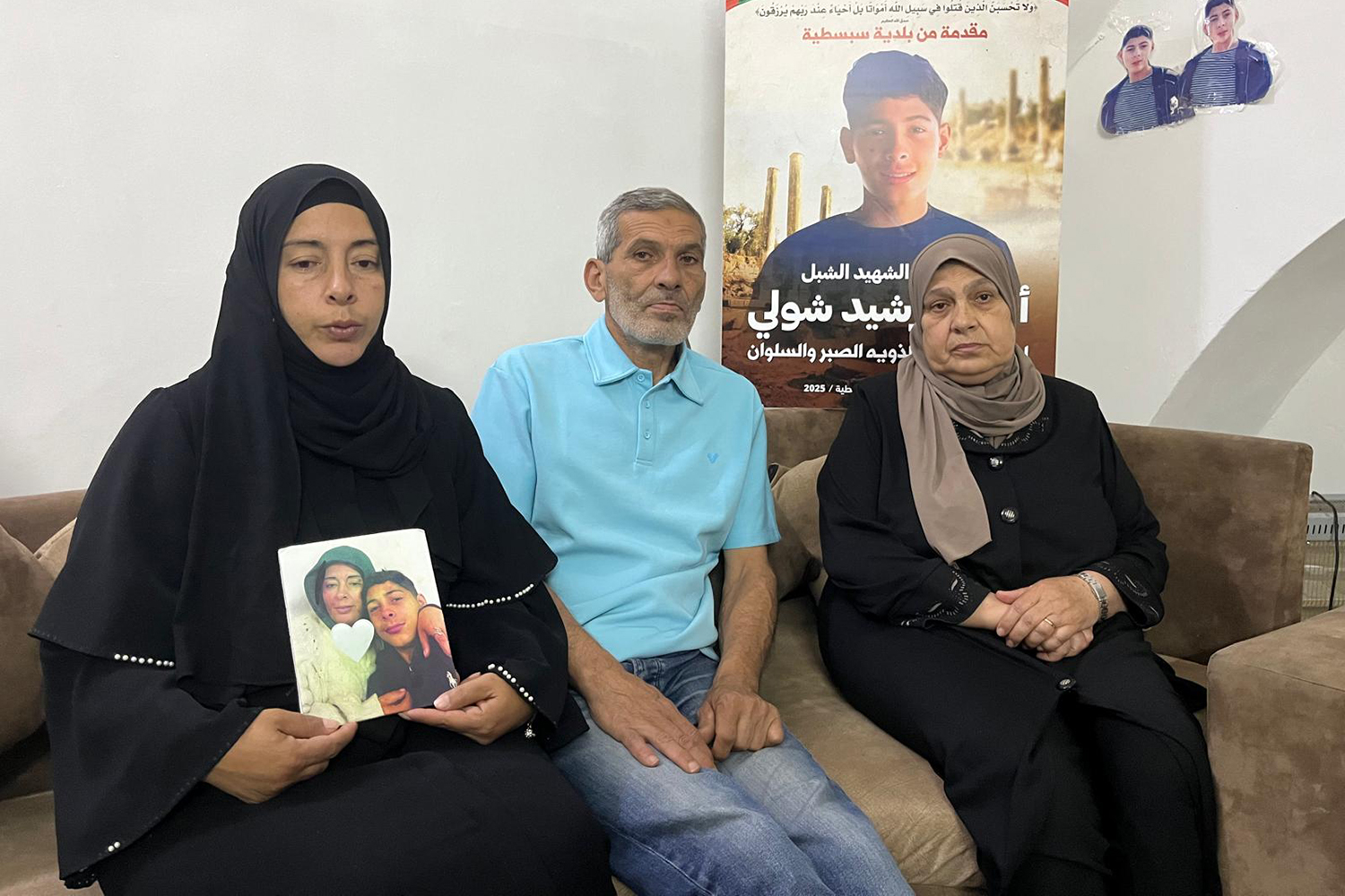 Wafaa clutches a photo of her murdered son as she sits with Rashid amd Ahmed's aunt Etizaz Azim 