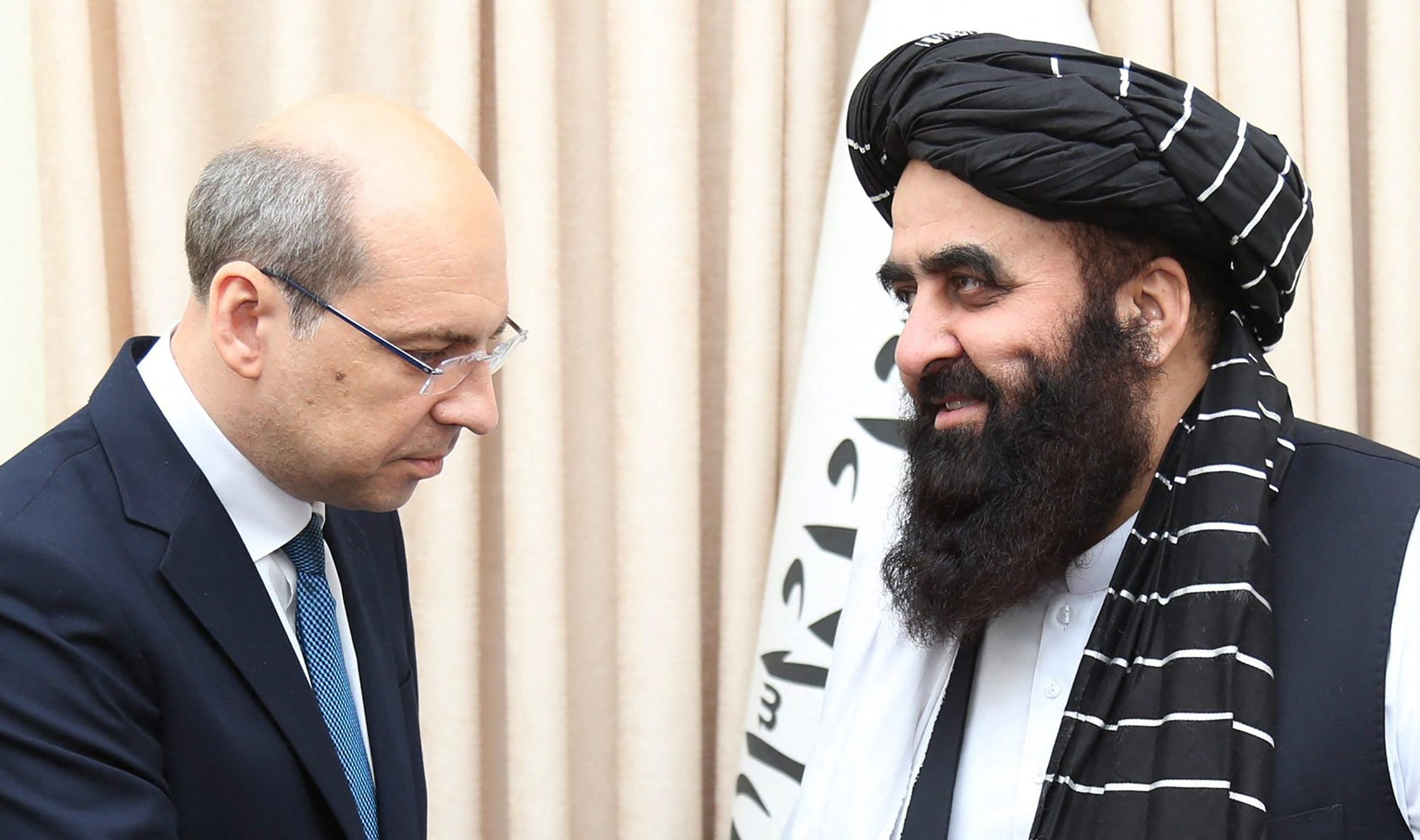 This handout photograph taken on July 3, 2025 and released by Afghanistan's Ministry of foreign Affairs shows Afghanistan’s Foreign Minister Amir Khan Muttaqi (R) shaking hands with Russia’s ambassador to Afghanistan Dmitry Zhirnov during their meeting at the foreign ministry in Kabul.