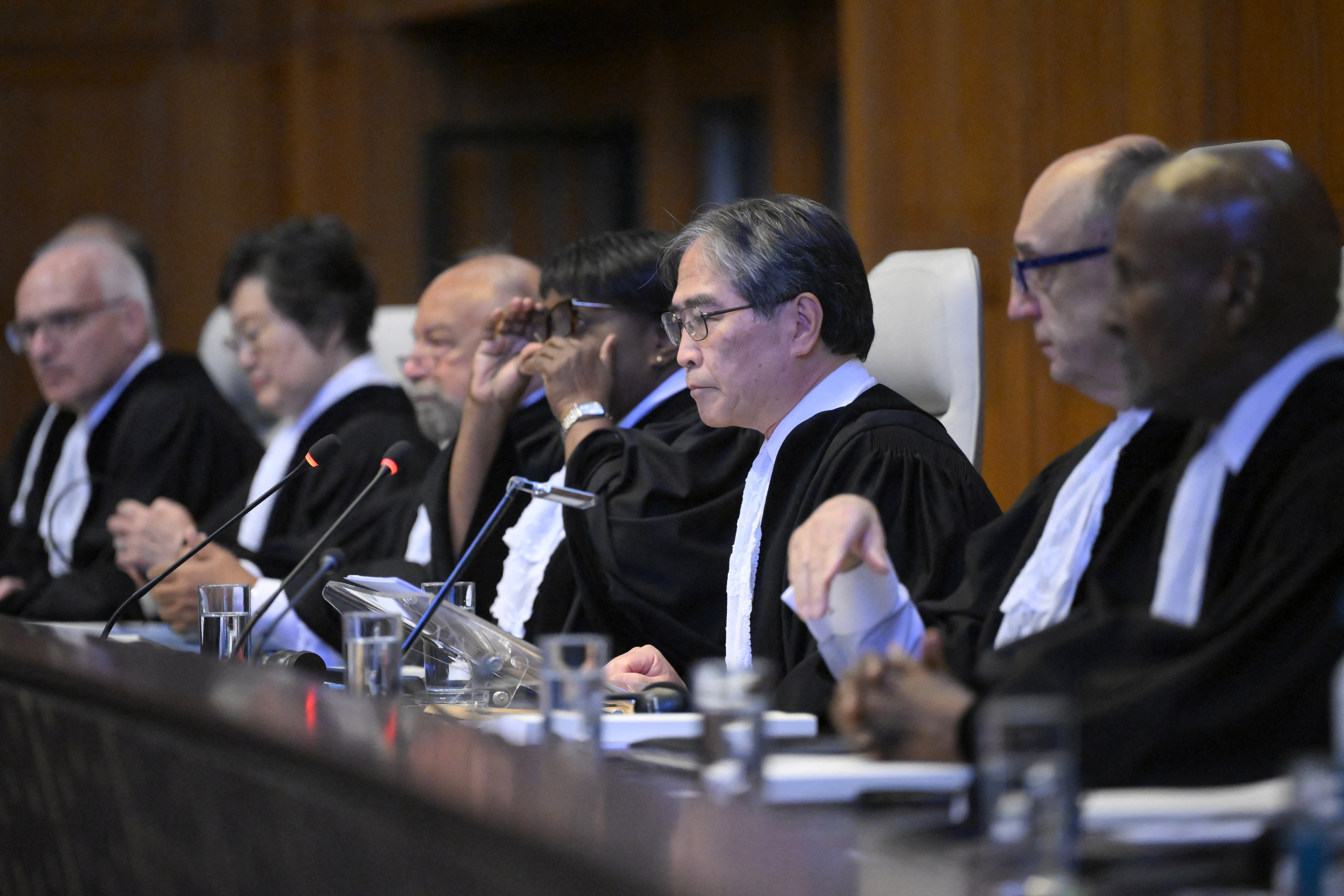 President of the International Court of Justice (ICJ) Yuji Iwasawa (C) and members issue first Advisory Opinion (AO) on States' legal obligations to address climate change, in The Hague on July 23, 2025.