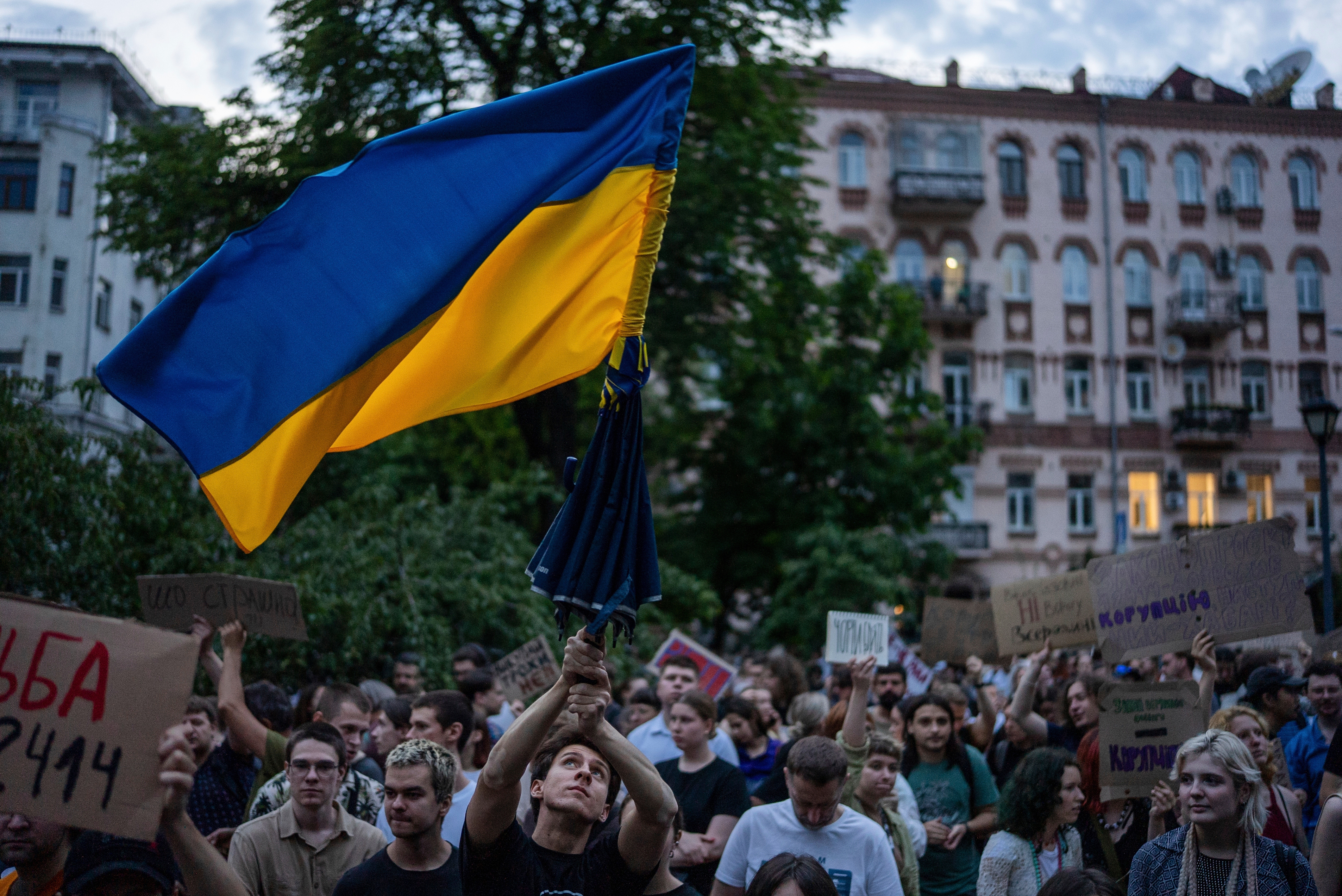 A man waves a flag during a protest against a law targeting anti-corruption institutions in central Kyiv, Ukraine, Tuesday, July 22, 2025. (AP Photo/Alex Babenko)