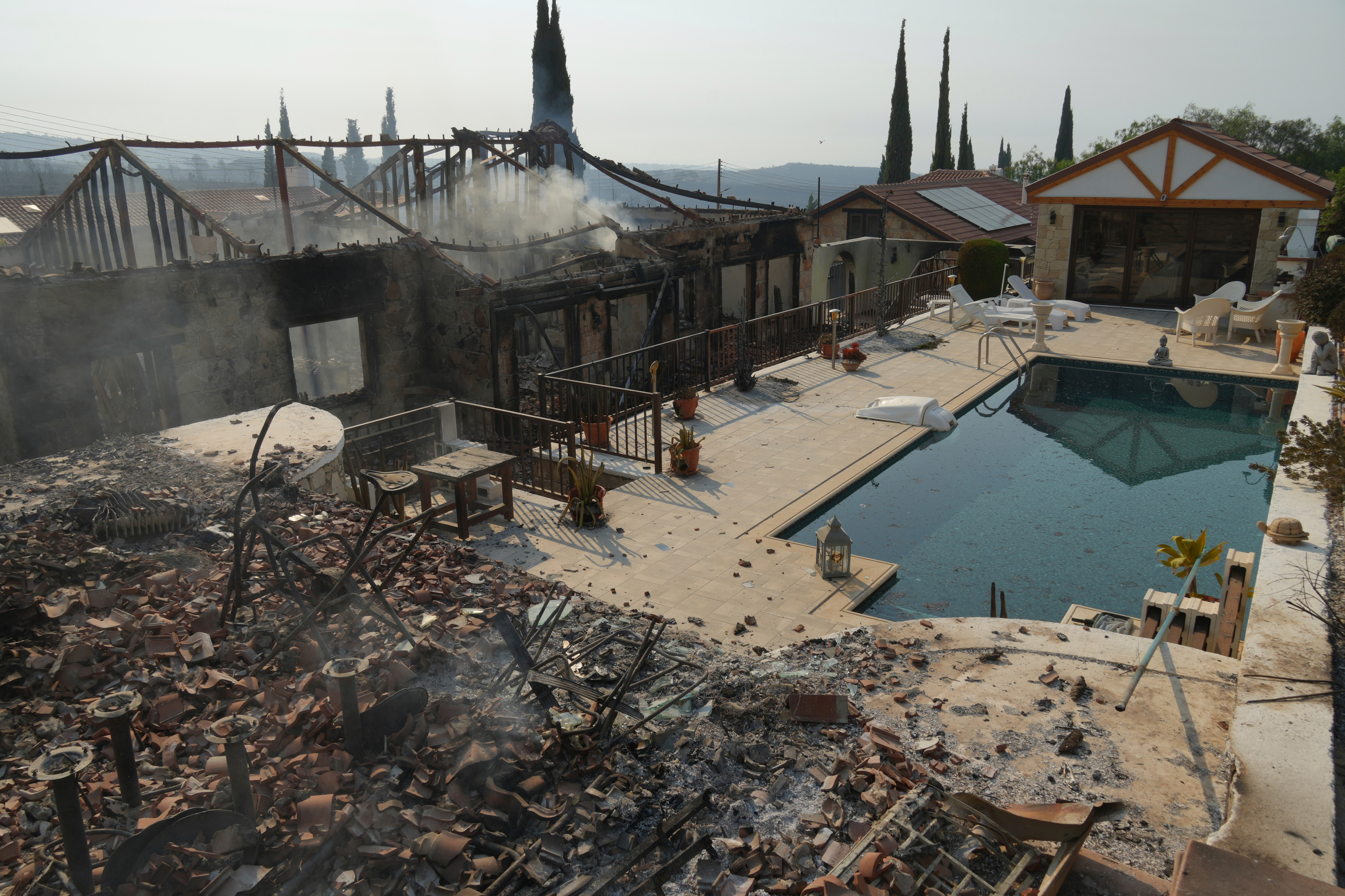 Burned houses are seen in Souni village, Cyprus, during a massive wildfire on the southern side of the east Mediterranean island nation's Troodos mountain range, Thursday, July 24, 2025. (AP Photo/Petros Karadjias)
