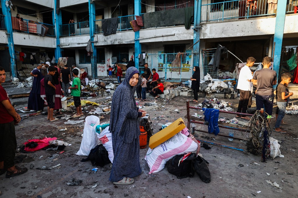 Palestinians salvage items from the debris of a tent which was hit in Israeli strikes a day earlier, at the UNRWA-run Abou Helou school for girls at the Bureij refugee camp in the central Gaza Strip on July 17, 2025. [Eyad Baba/ AFP]